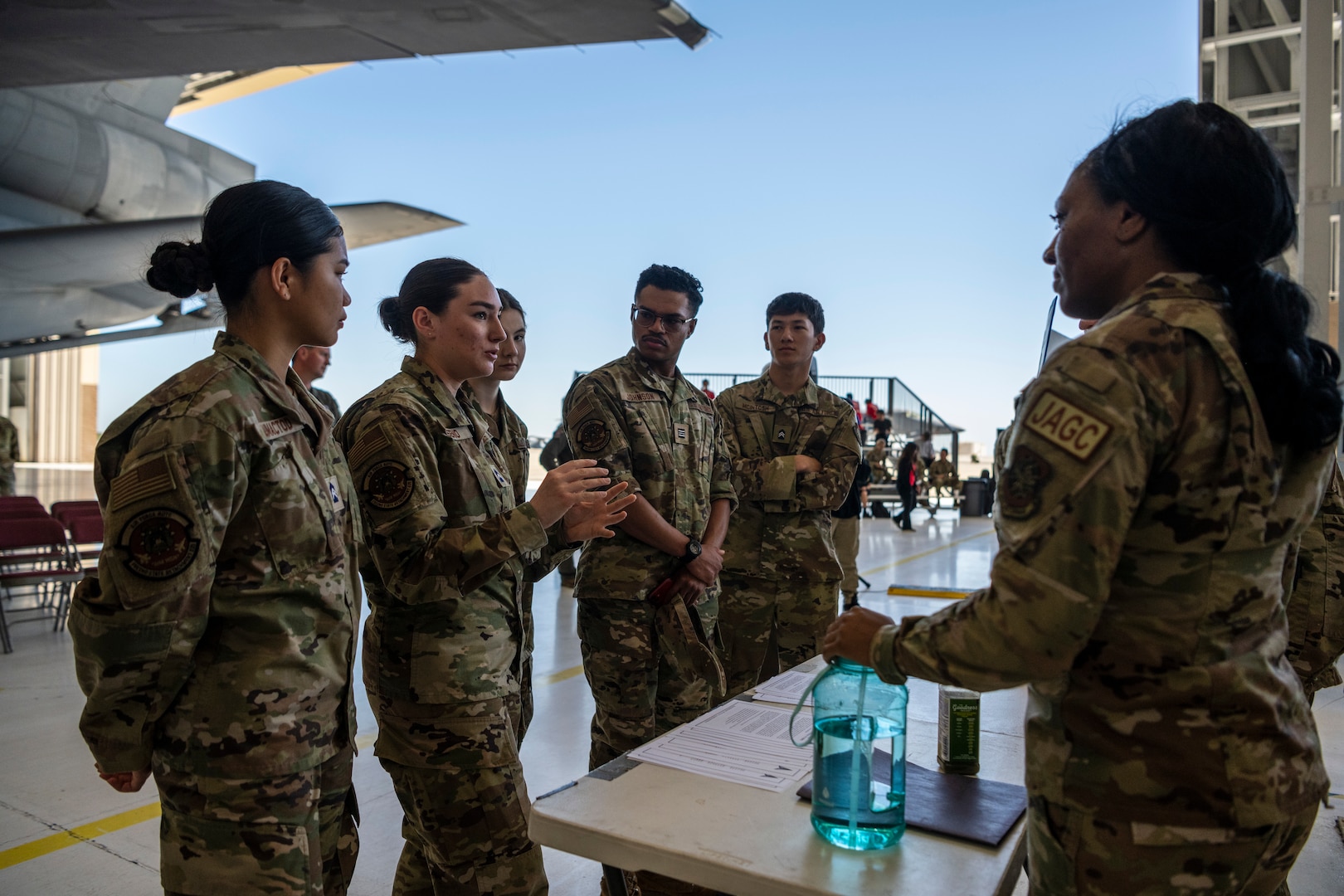 A woman speaks with students at a table.