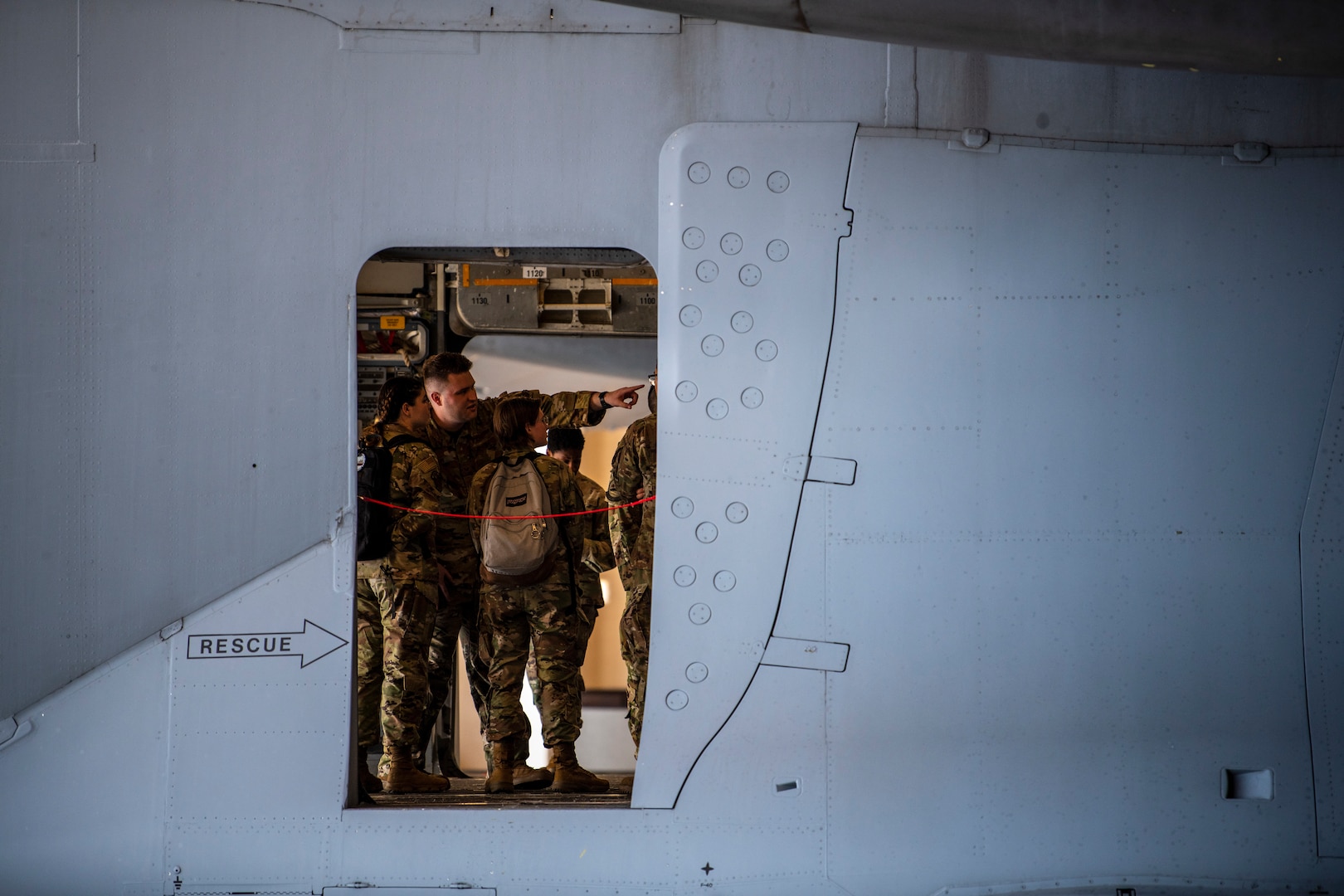 People stand inside a large military aircraft.