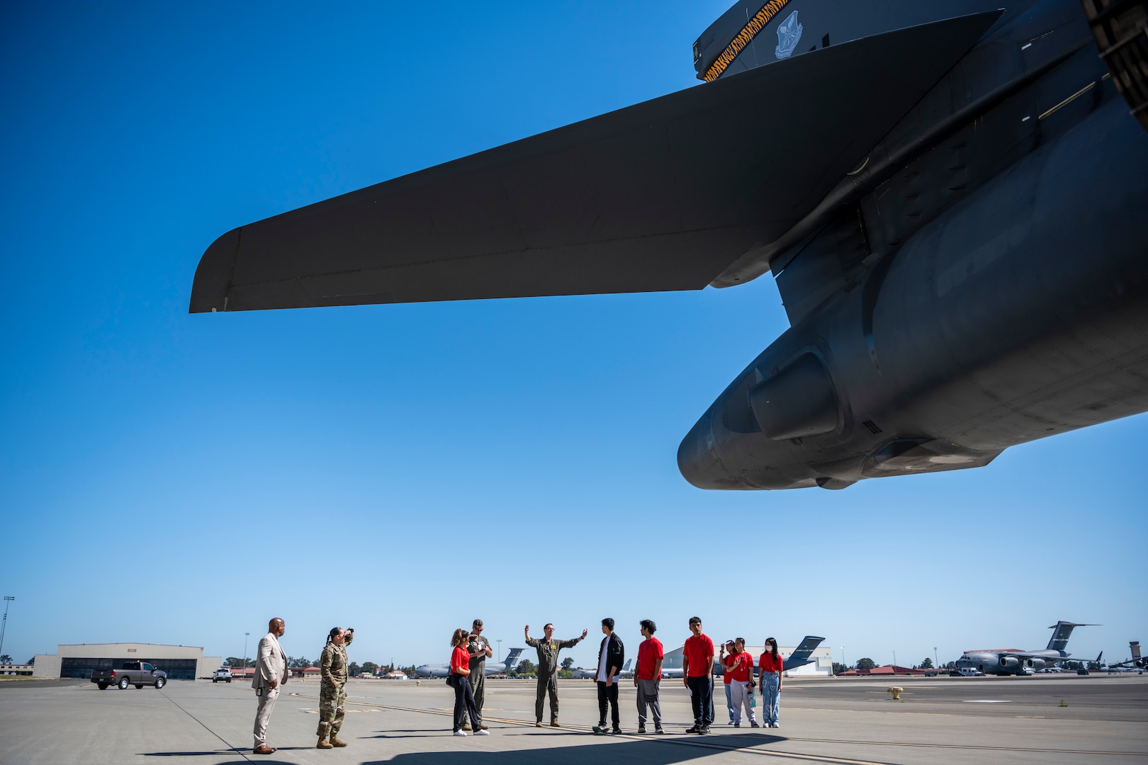 People stand around a military aircraft.