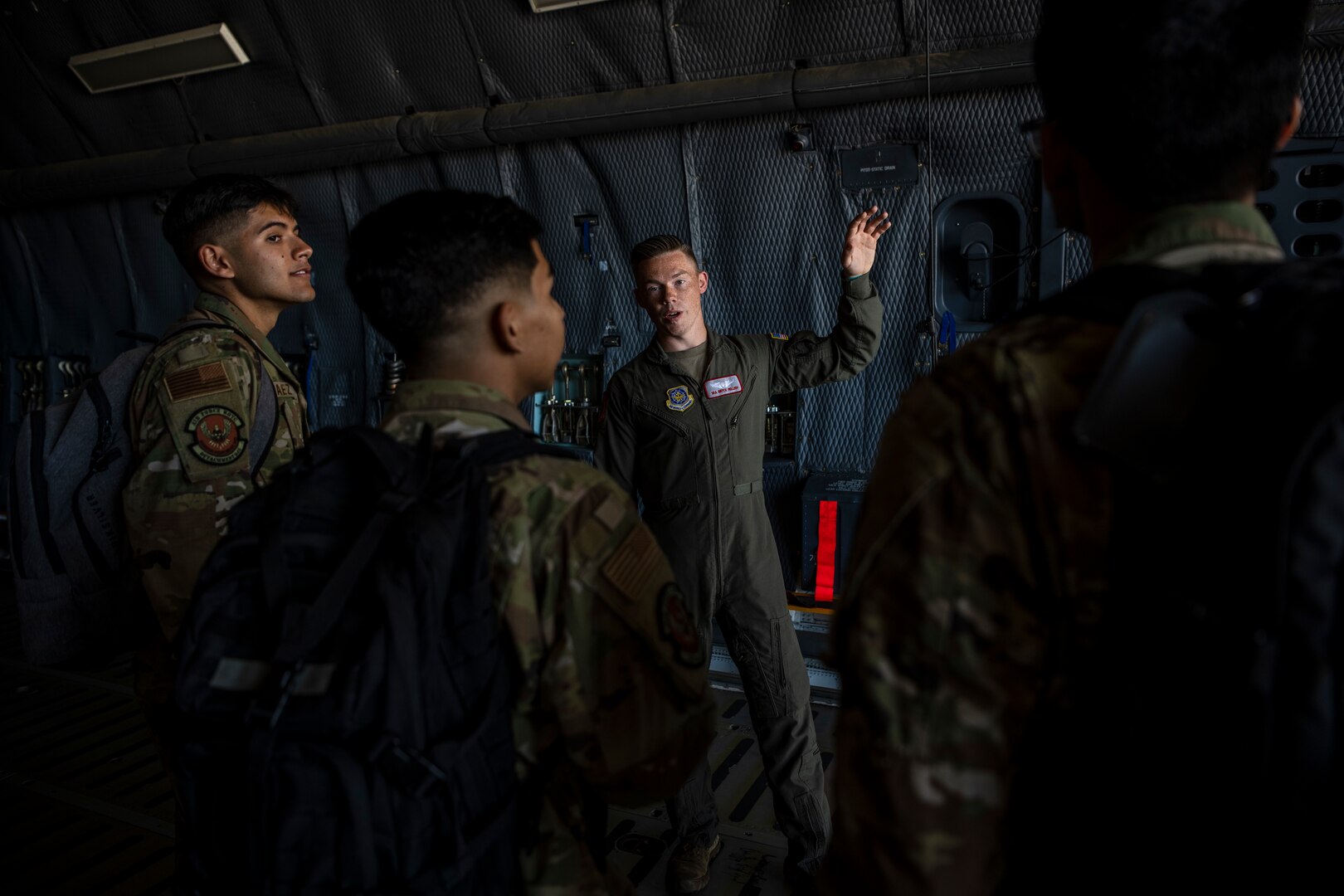 People stand inside a large military aircraft.