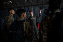 People stand inside a large military aircraft.