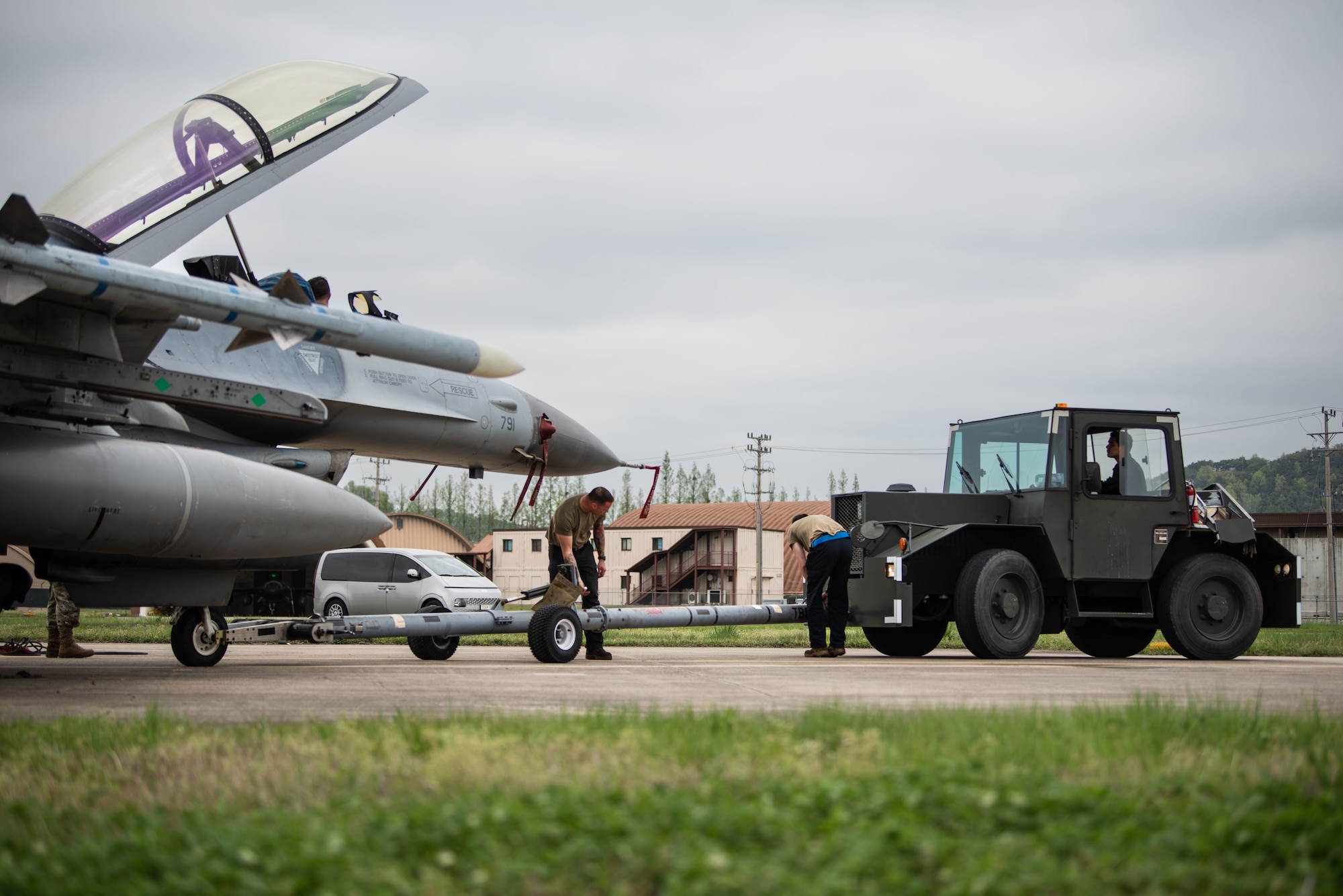 Maintainers operate a tow vehicle to get a jet in place