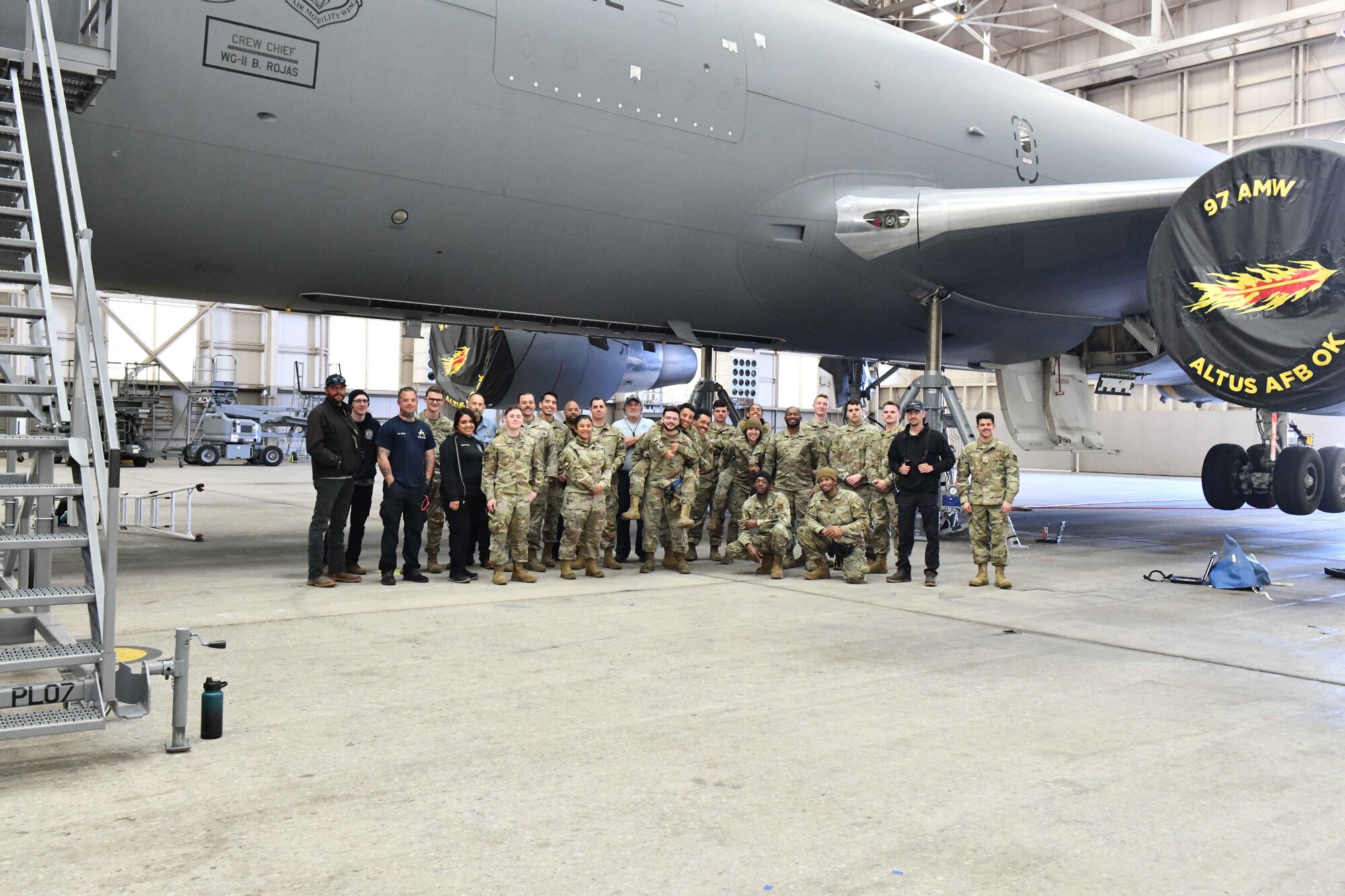 Airmen from the 97th Aircraft Maintenance Squadron (AMXS) at Altus Air Force Base (AFB), Oklahoma and the 660th AMXS at Travis Air Force Base, Calif., pose in front of a suspended KC-46 Pegasus at Altus AFB, April 18, 2023. Members of the 97th AMXS trained maintainers from Travis on the KC-46 from February to May 2023. (U.S. Air Force photo by Airman 1st Class Miyah Gray)
