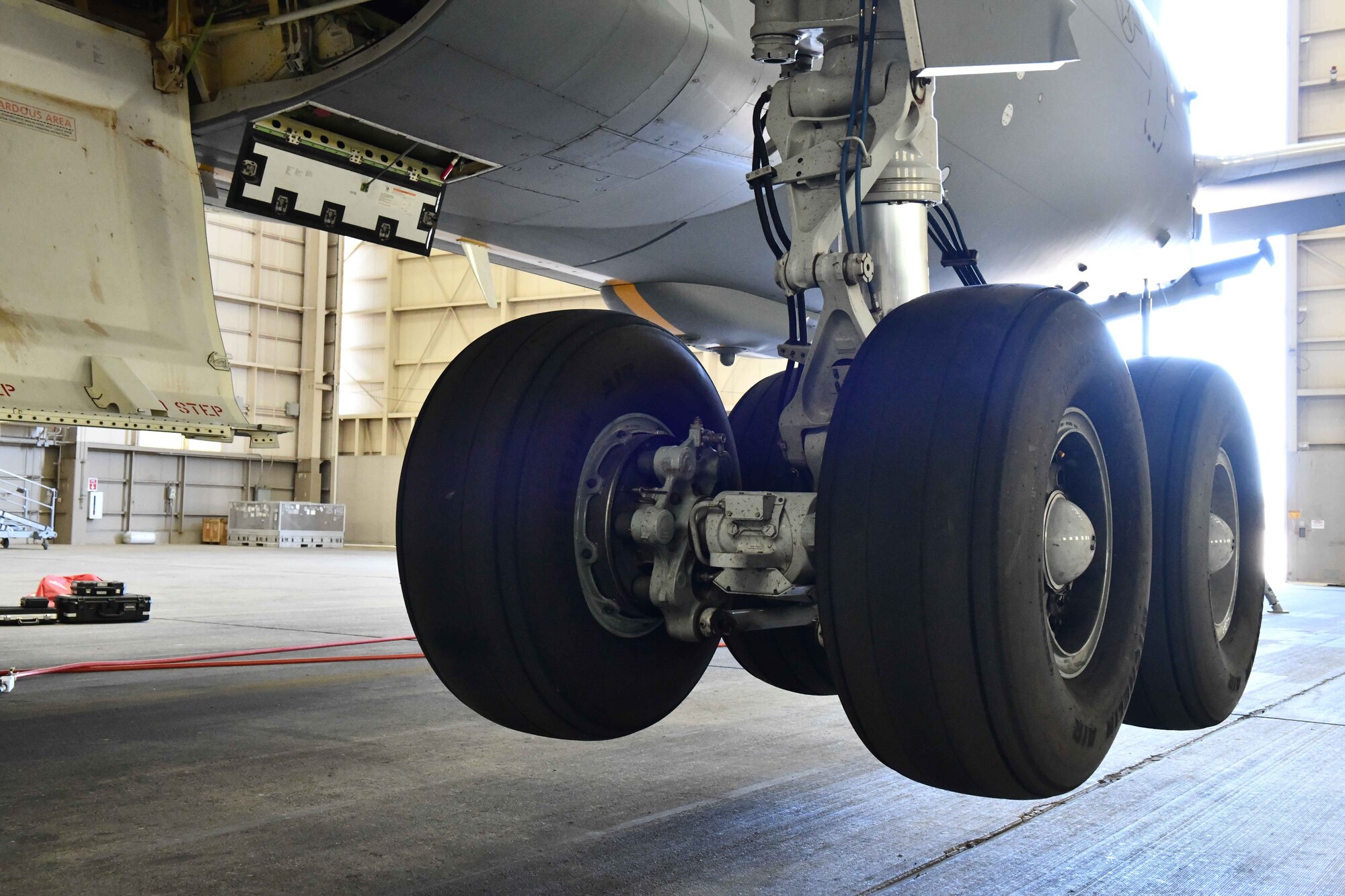 The wheels of a KC-46 Pegasus are suspended at Altus Air Force Base, Oklahoma, April 18, 2023. Maintainers use aircraft jacks when changing tires and oiling wheel bearings. (U.S. Air Force photo by Airman 1st Class Miyah Gray)