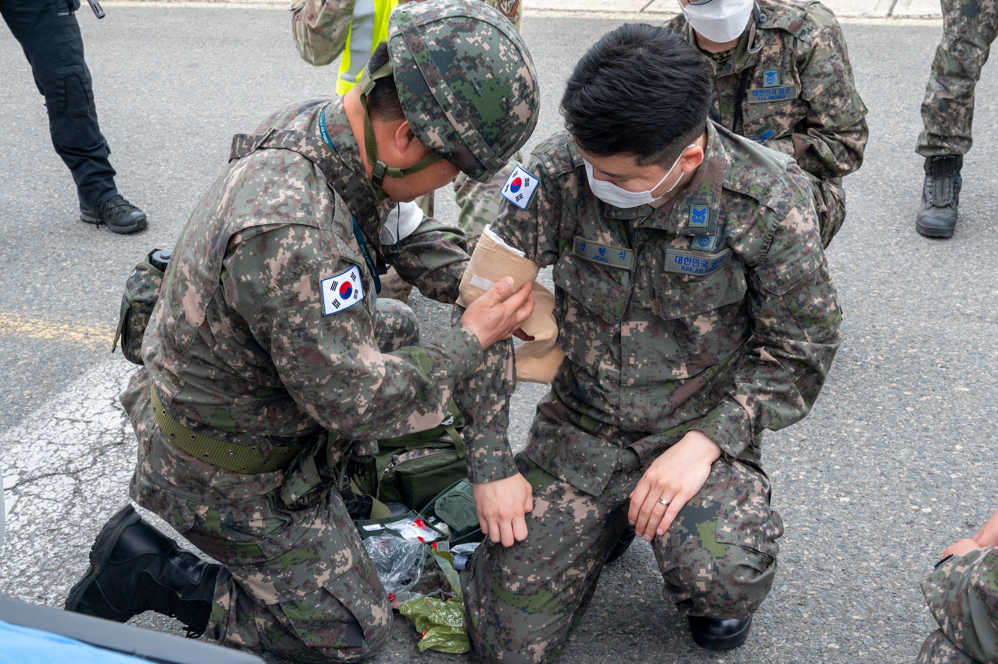 Republic of Korea Air Force medical personnel apply first-aid to a simulated victim during an active shooter training event at Daegu Air Base, ROK, April 24, 2023. U.S. and ROK personnel evaluated ROKAF fire and medical responses to see how they can be interlocked with U.S. operations. (U.S. Air Force photo by Airman 1st Class Aaron Edwards)