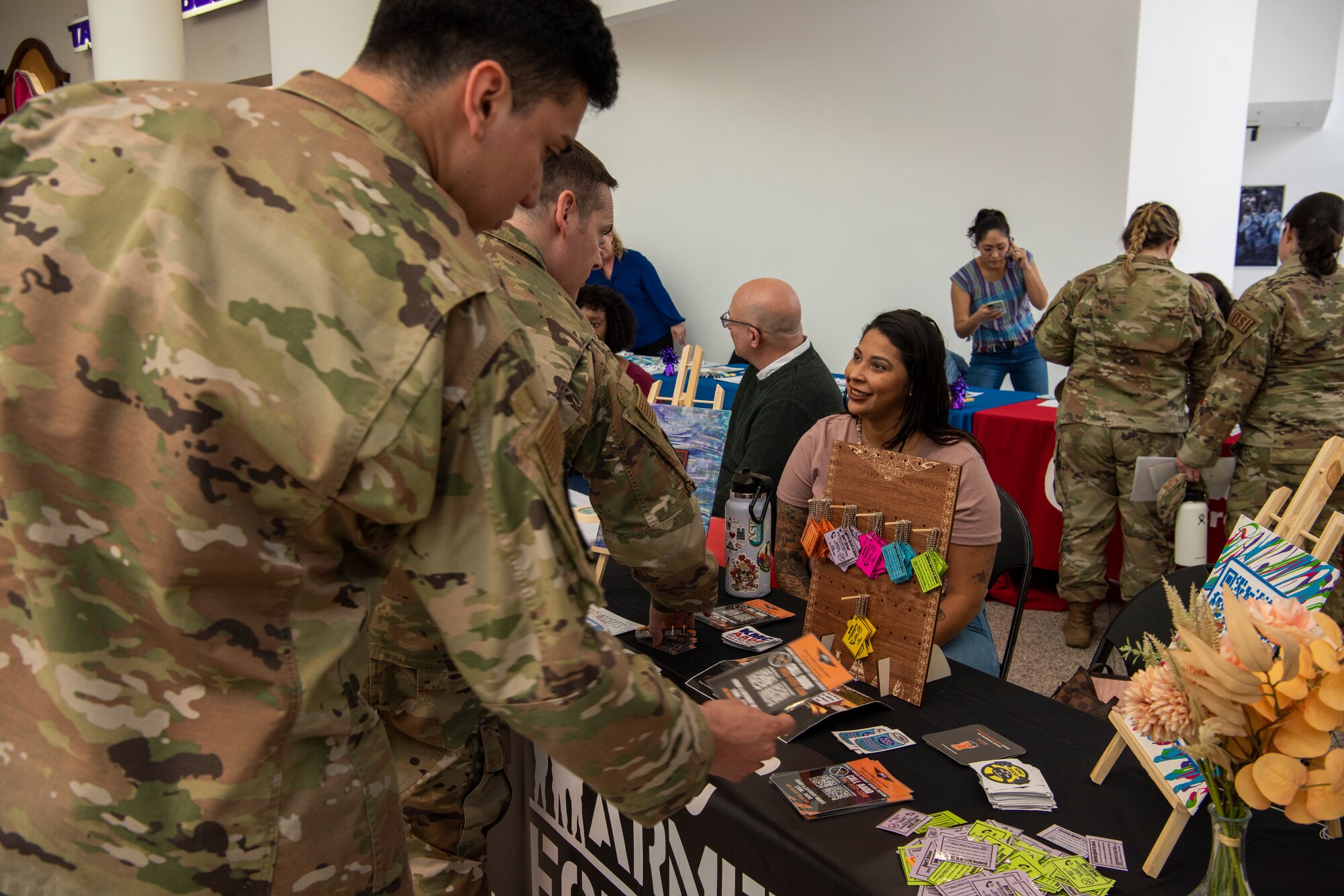 U.S. Air Force Tech. Sgt. Amanda Martinez, right, 86th Airlift Wing integrated resilience non-commissioned officer in charge, greets Airmen during an e-CheckUptoGo information fair at Ramstein Air Base, Germany, April 27, 2023.
