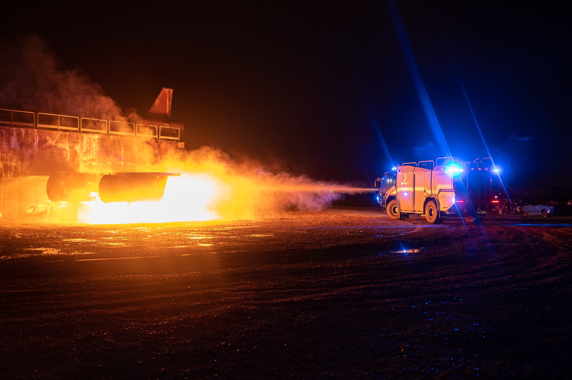 A 100th Civil Engineer Squadron fire and emergency service driver, sprays the rear of a simulated KC-135 Stratotanker aircraft fire during a base-wide exercise at Royal Air Force Mildenhall, England, April 27, 2023.