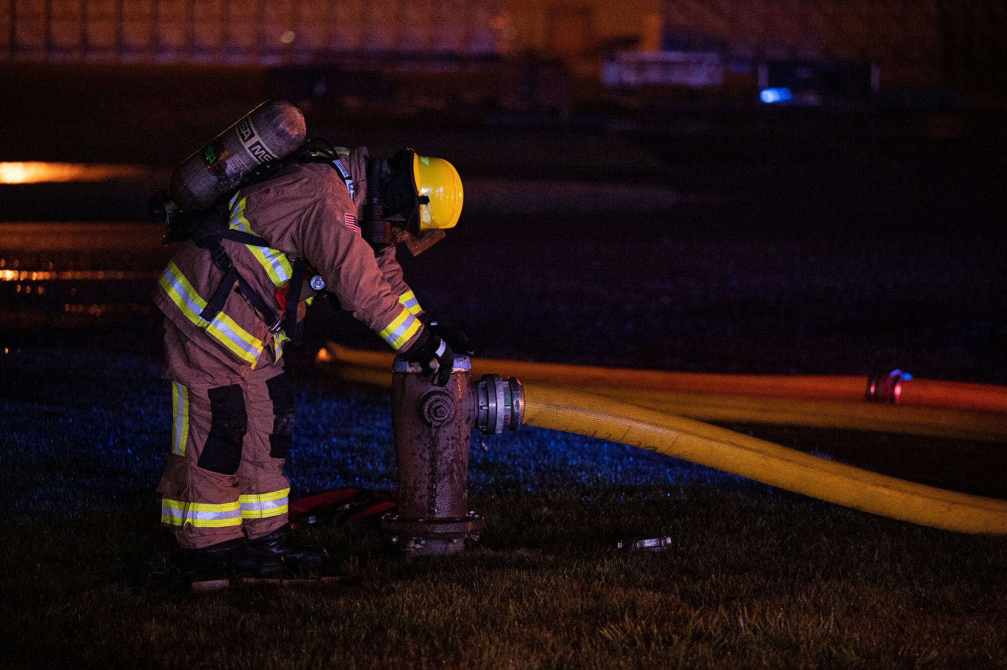 A 100th Civil Engineer Squadron firefighter, connects a hose to a fire hydrant during a base-wide exercise at Royal Air Force Mildenhall, England, April 27, 2023.