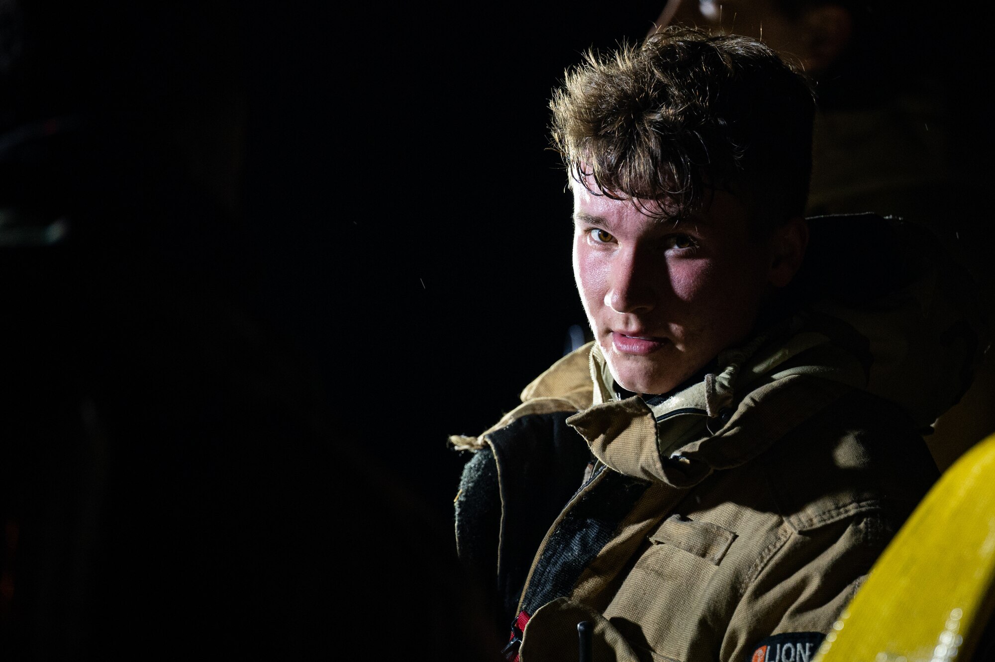 U.S. Air Force Airman 1st Class Charlie Bowers, 100th Civil Engineer Squadron firefighter, rests following the suppression of a simulated aircraft fire during a base-wide exercise at Royal Air Force Mildenhall, England, April 27, 2023.