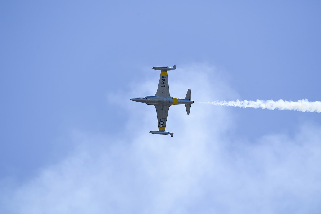 An Air Force aircraft is photographed from below as it flies.