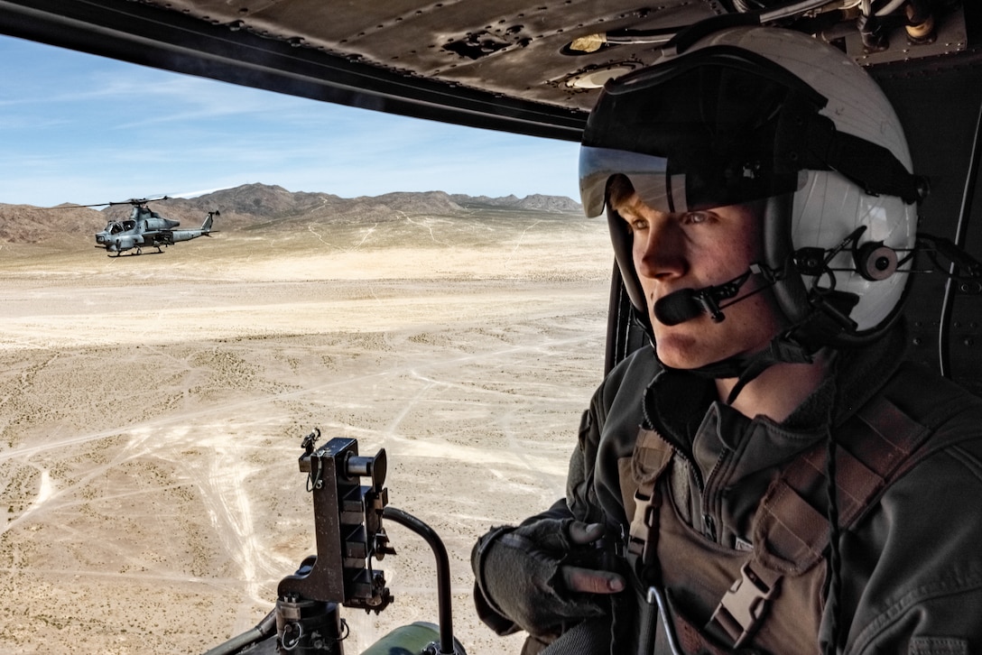 U.S. Marine Corps Lance Cpl.  Roberts, a UH-1Y Venom Crew Chief with Marine Light Attack Helicopter Squadron (HMLA) 367, Marine Aircraft Group 39, 3rd Marine Aircraft Wing, observes surroundings during a training flight during National Training Center Rotation 23-07 at Fort Irwin, California, April 27, 2023. During the exercise, HMLA-367 supported 75th Ranger Regiment and 3/160th Special Operations Aviation Regiment (SOAR) as the sole rotary-wing fire support element, enhancing joint planning and execution of long-range assault force escort, deep and close air support, and direct-action raids. Roberts is a native of Plano, Texas. (U.S. Marine Corps photo by Lance Cpl. . Devereux)