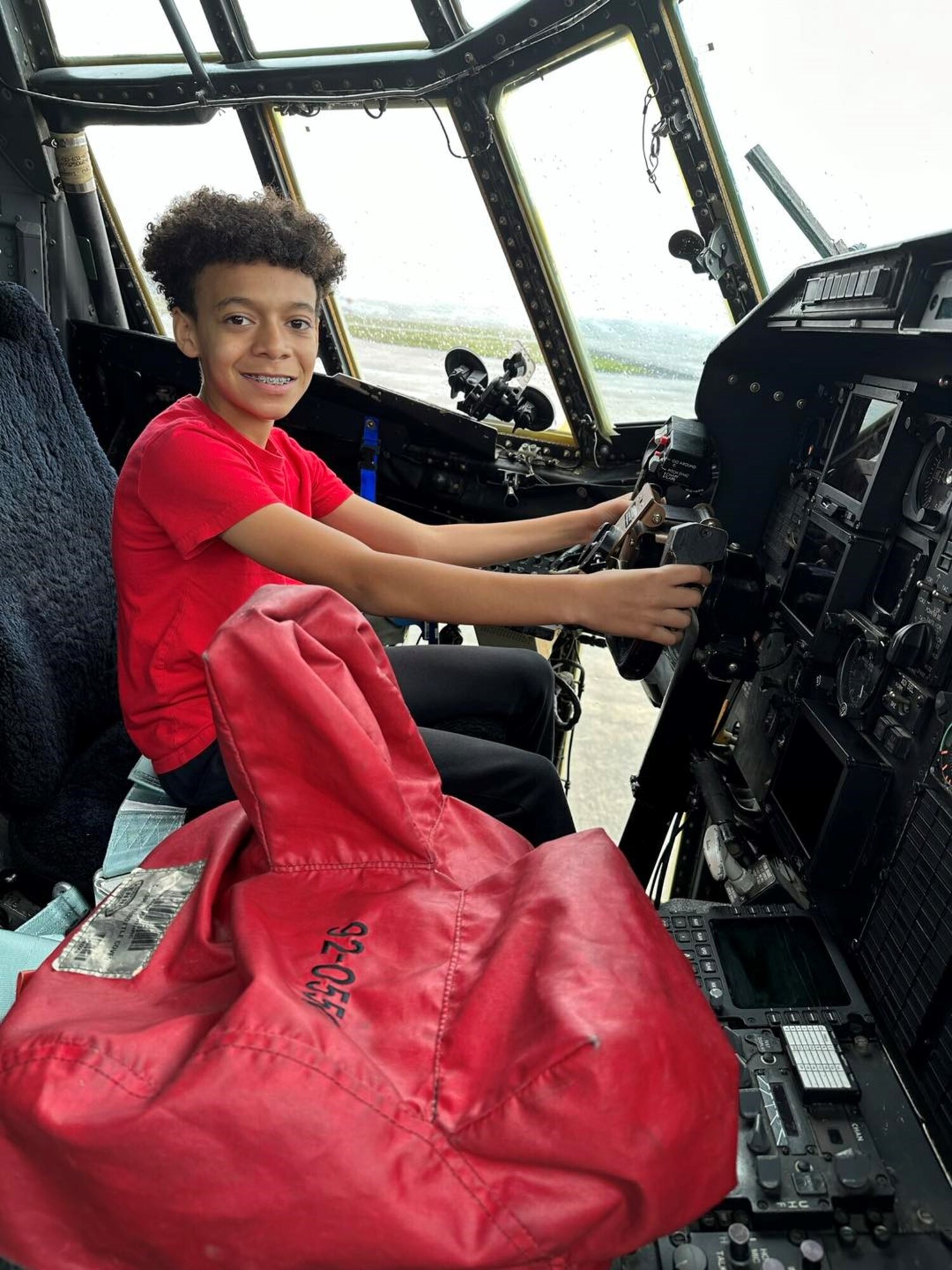 a child sits inside the cockpit of an airplane