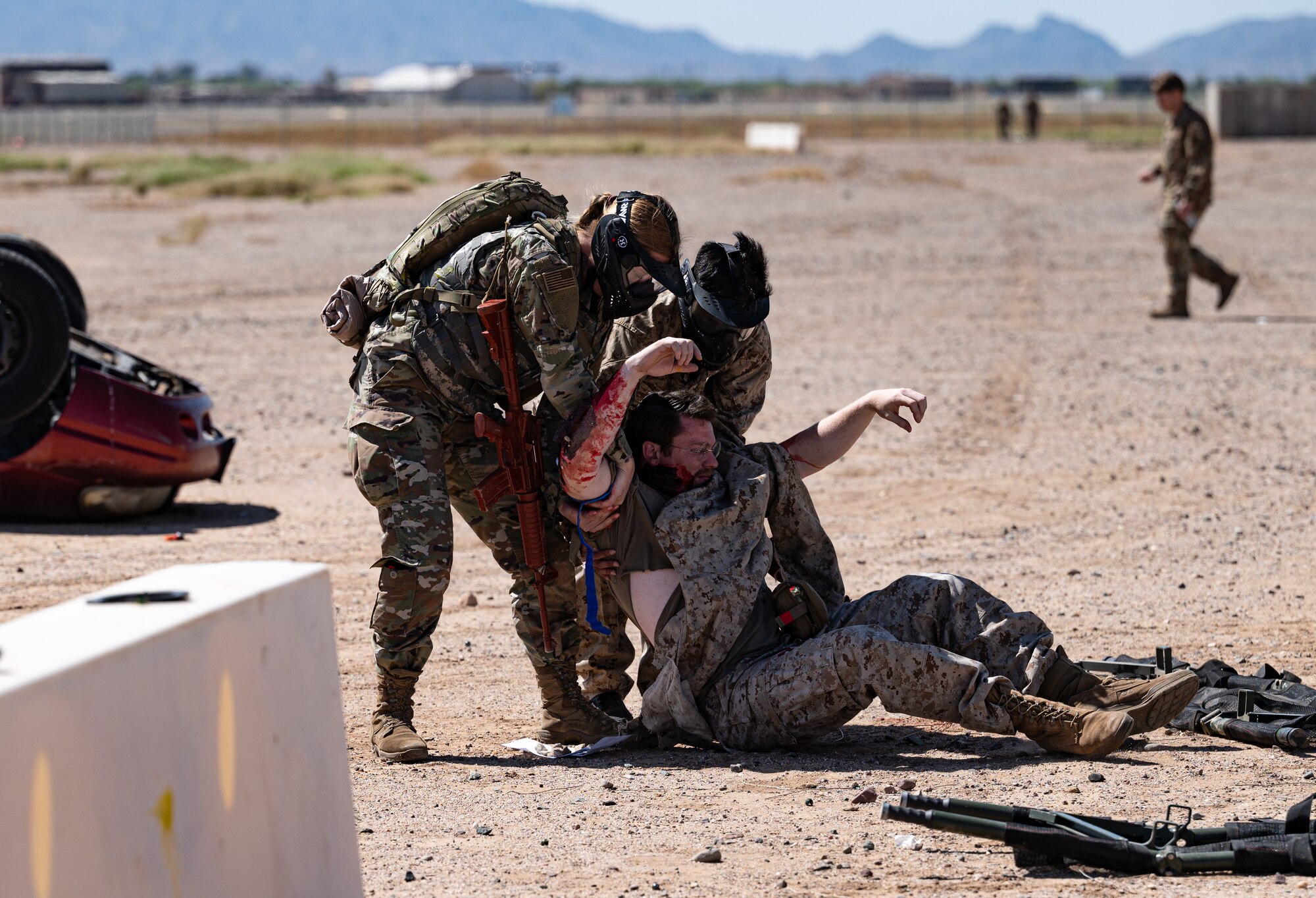 U.S. Air Force 56th Medical Group healthcare specialists drag a simulated patient to safety during a Tactical Combat Casualty Care exercise April 26, 2023, at Luke Air Force Base, Arizona.