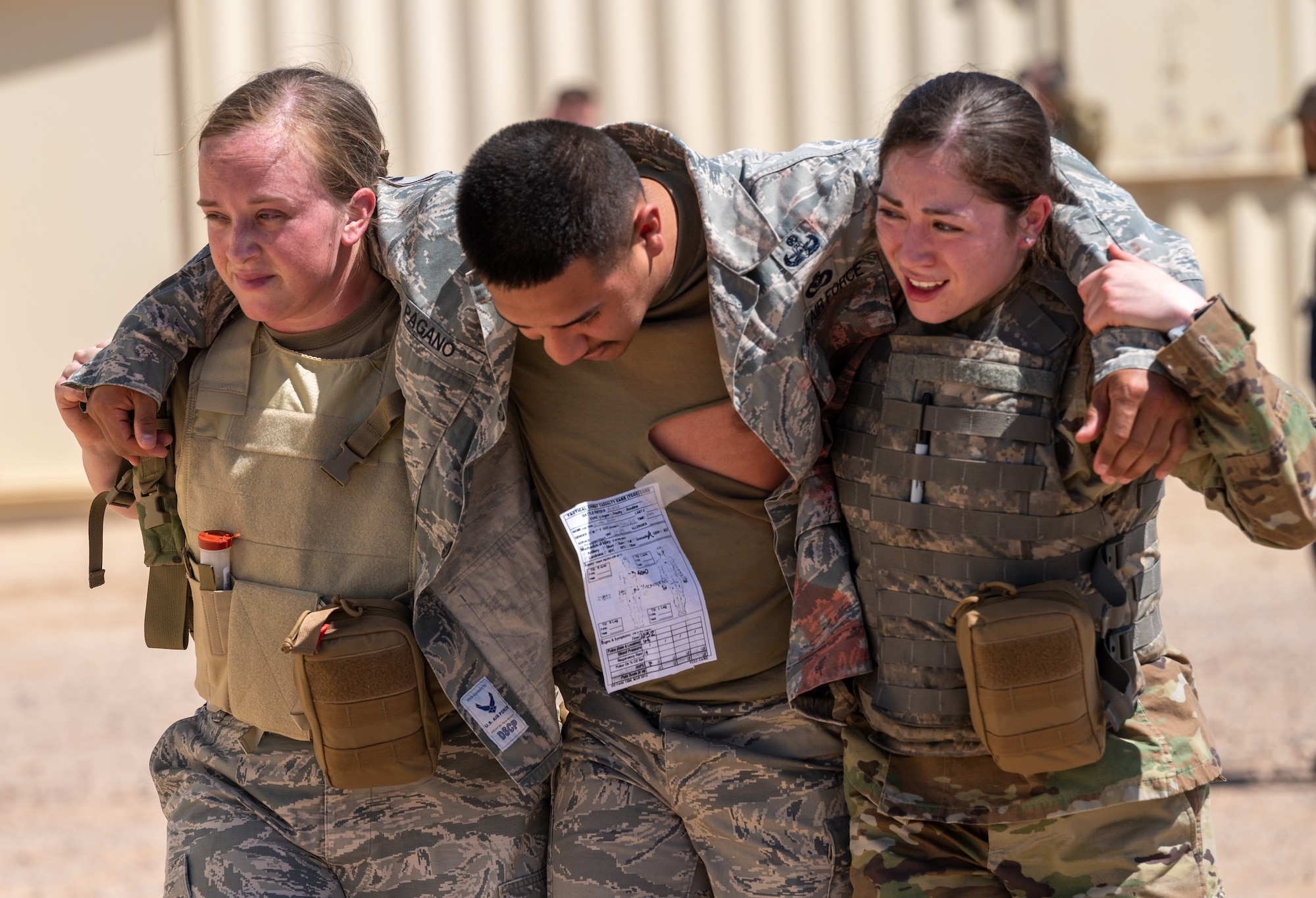 U.S. Air Force SSgt. Katlyn Hall (left) and SrA Gabriella Zuniga (right), 56th Medical Group healthcare specialists, carry a simulated patient to safety during a Tactical Combat Casualty Care exercise April 26, 2023, at Luke Air Force Base, Arizona.