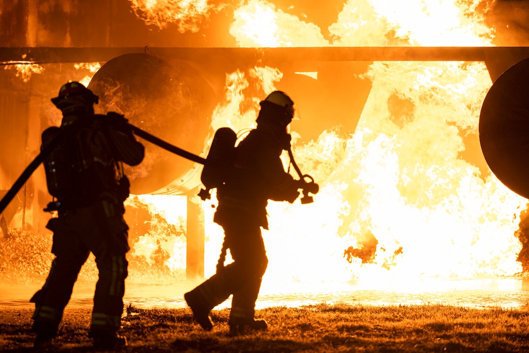 Firefighters used a hose to put out an aircraft fire in the dark.