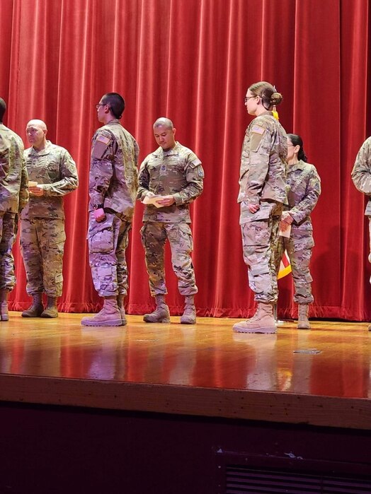  U.S. Space Force Senior Master Sgt. Anthony Chua, 1st Delta Operations Squadron, Detachment 1 senior enlisted leader, center, prepares to place his U.S. Space Force patch on his son, U.S. Space Force Spc. 3 Anthony "AJ" Chua, during the Guardian Recognition and Patching Ceremony at Lackland Air Force Base, Texas, April 25, 2023. AJ is following in his father's footsteps of serving in the Space Force, enlisting as a cyber operations specialist. (Courtesy photo)