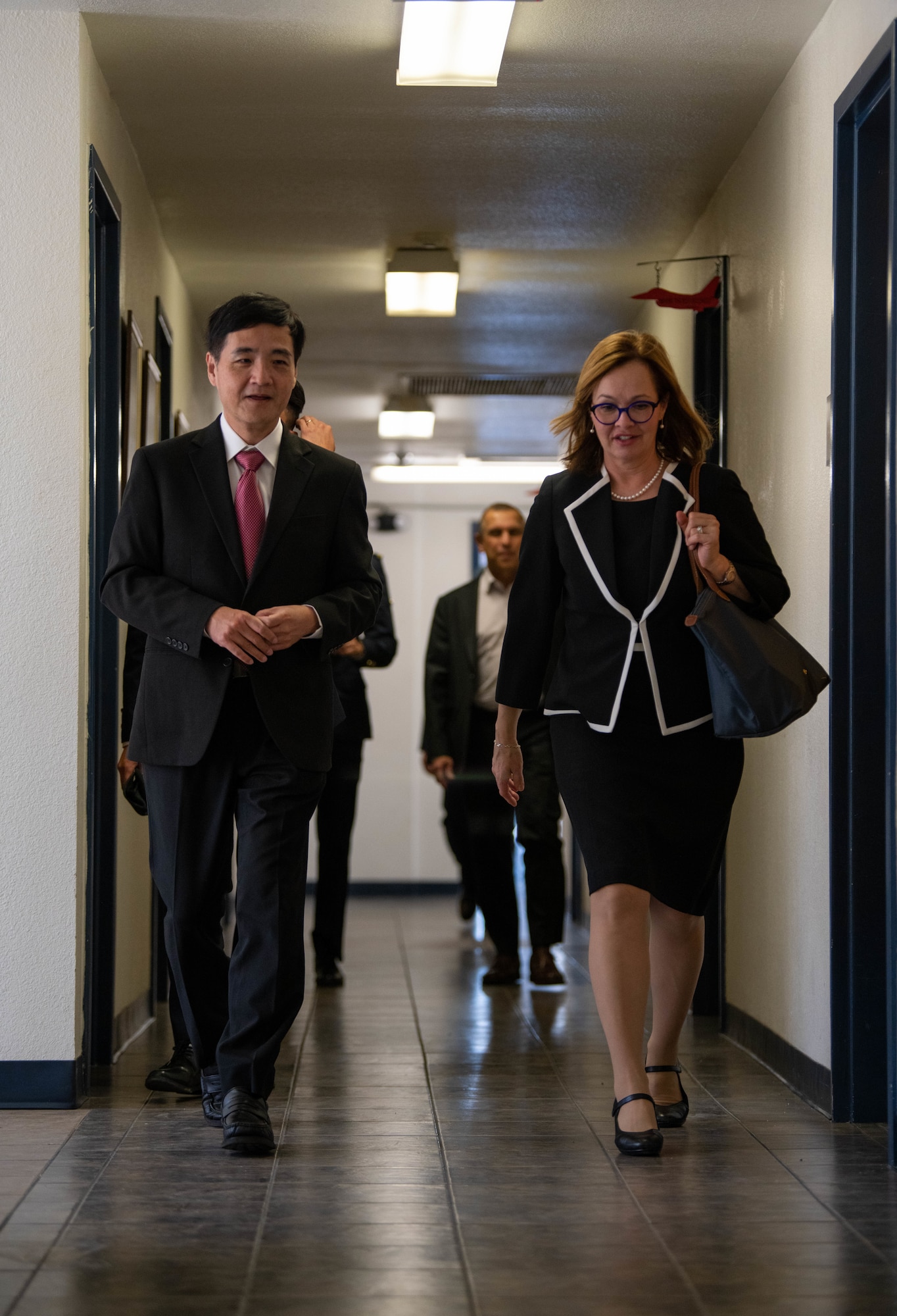 Heng Chee How (left), Republic of Singapore Senior Minister of State, and Kelli Seybolt (right), U.S. Air Force International Affairs Deputy Under Secretary, walk down a hallway to attend a meet and greet during the Republic of Singapore Air Force Peace Carvin II 30th Anniversary celebration event, April 25, 2023, at Luke Air Force Base, Arizona.