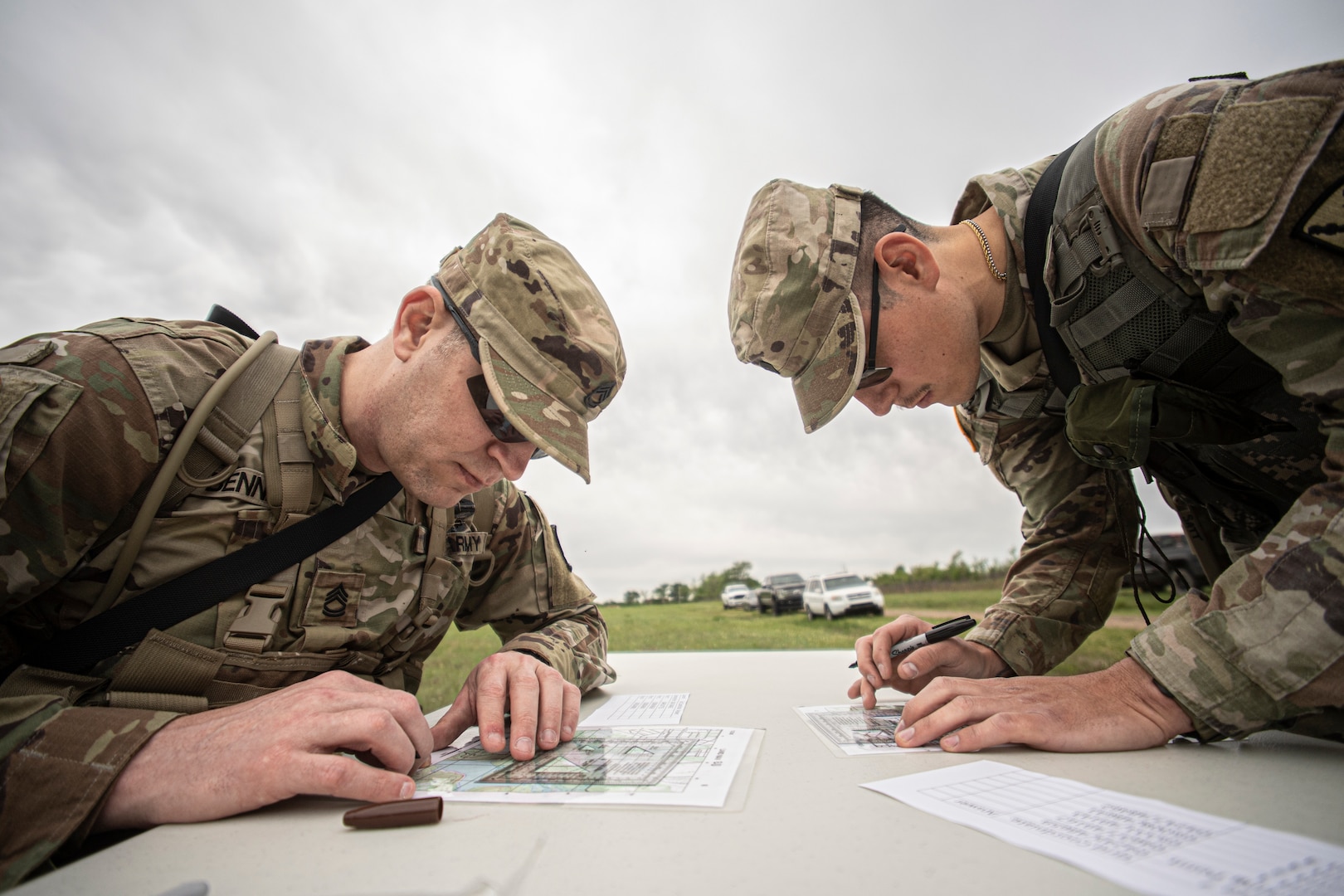 (left to right) Sgt. 1st Class Johnnie Bennett and Spc. Zuriel J. Bustos, both members of the 271st Brigade Support Battalion, plot points during the land navigation event of the 2023 Oklahoma Army National Guard Best Warrior Competition at Camp Gruber Training Center, Oklahoma, April 21. (Oklahoma National Guard photo by Sgt. Anthony Jones)