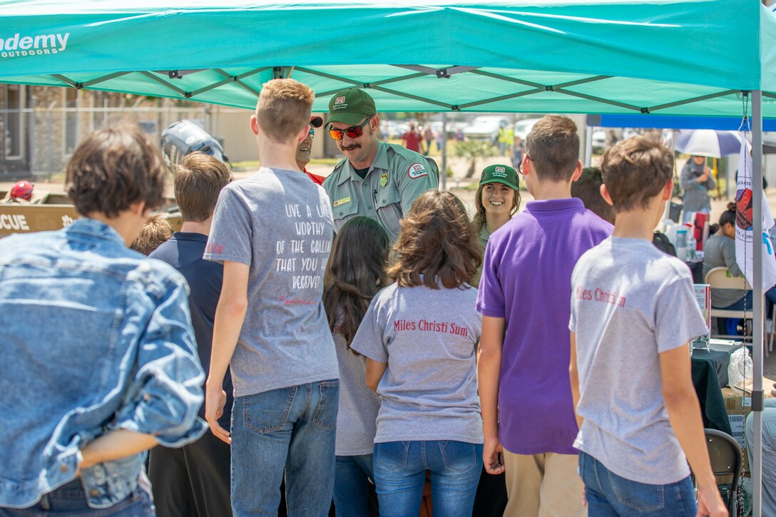 Zach Stafford, left, and Karly Sias, Park Rangers with the Galveston District, U.S. Army Corps of Engineers (USACE), hand water and hurricane safety information and discuss the district’s role in flood risk management to visitors of the Hurricane Hunter Aircraft display at Ellington Airport.