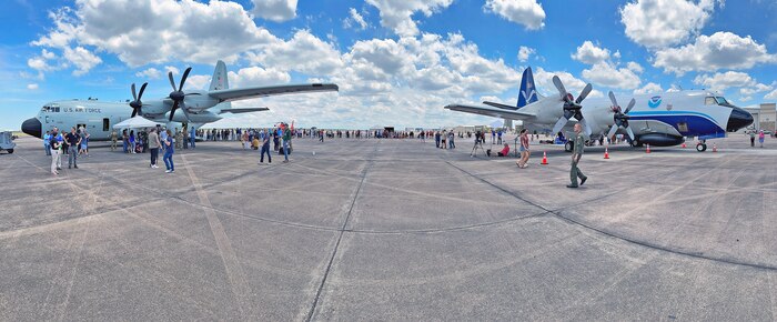 Visitors and staff of the Hurricane Hunter Aircraft display at Ellington Airport gather around a National Oceanic and Atmospheric Administration (NOAA) a WP-3D Orion aircraft, right, and an Air Force Reserve WC-130J hurricane hunter aircraft.