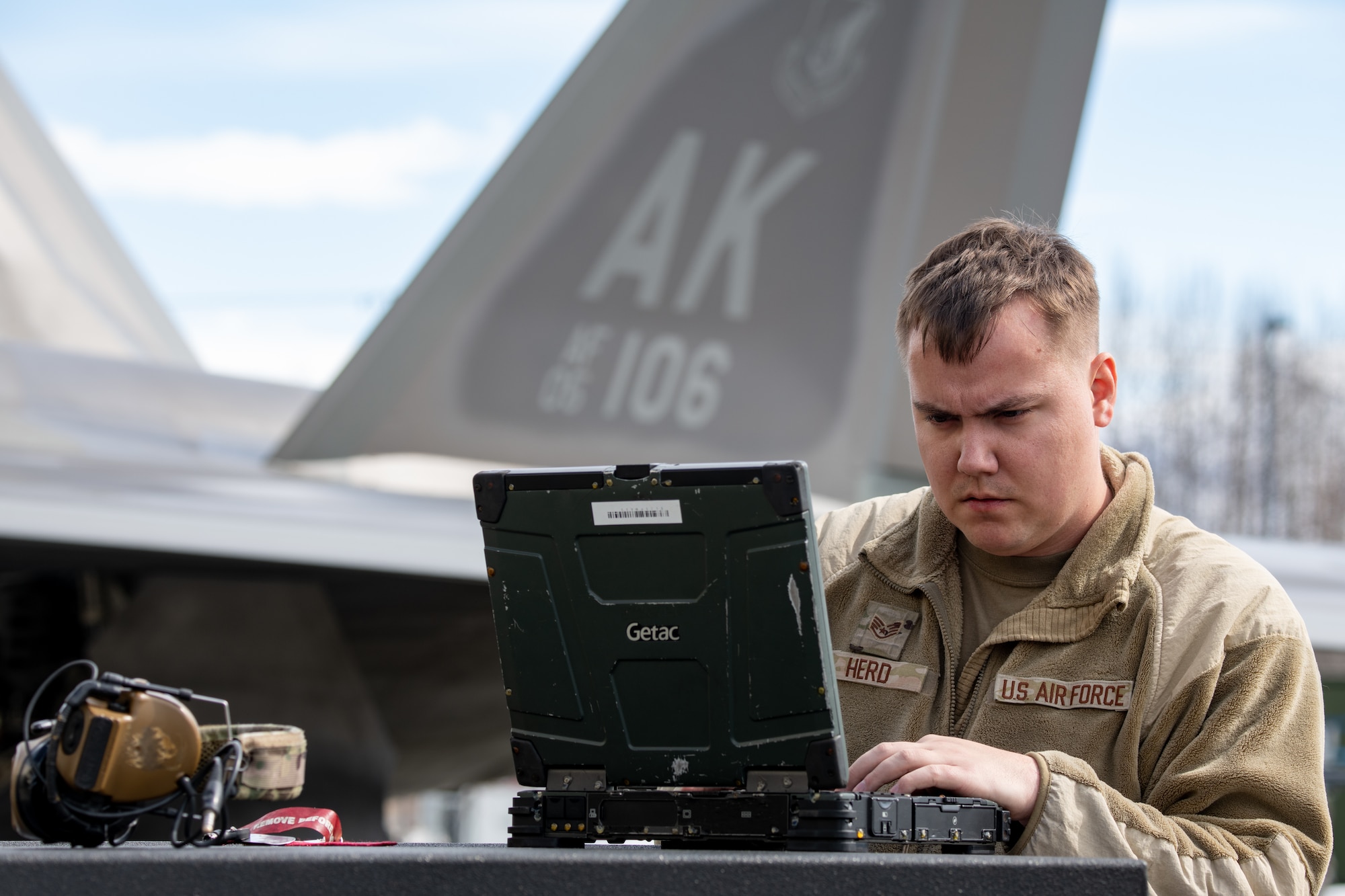 A photo of an Airman working on a laptop