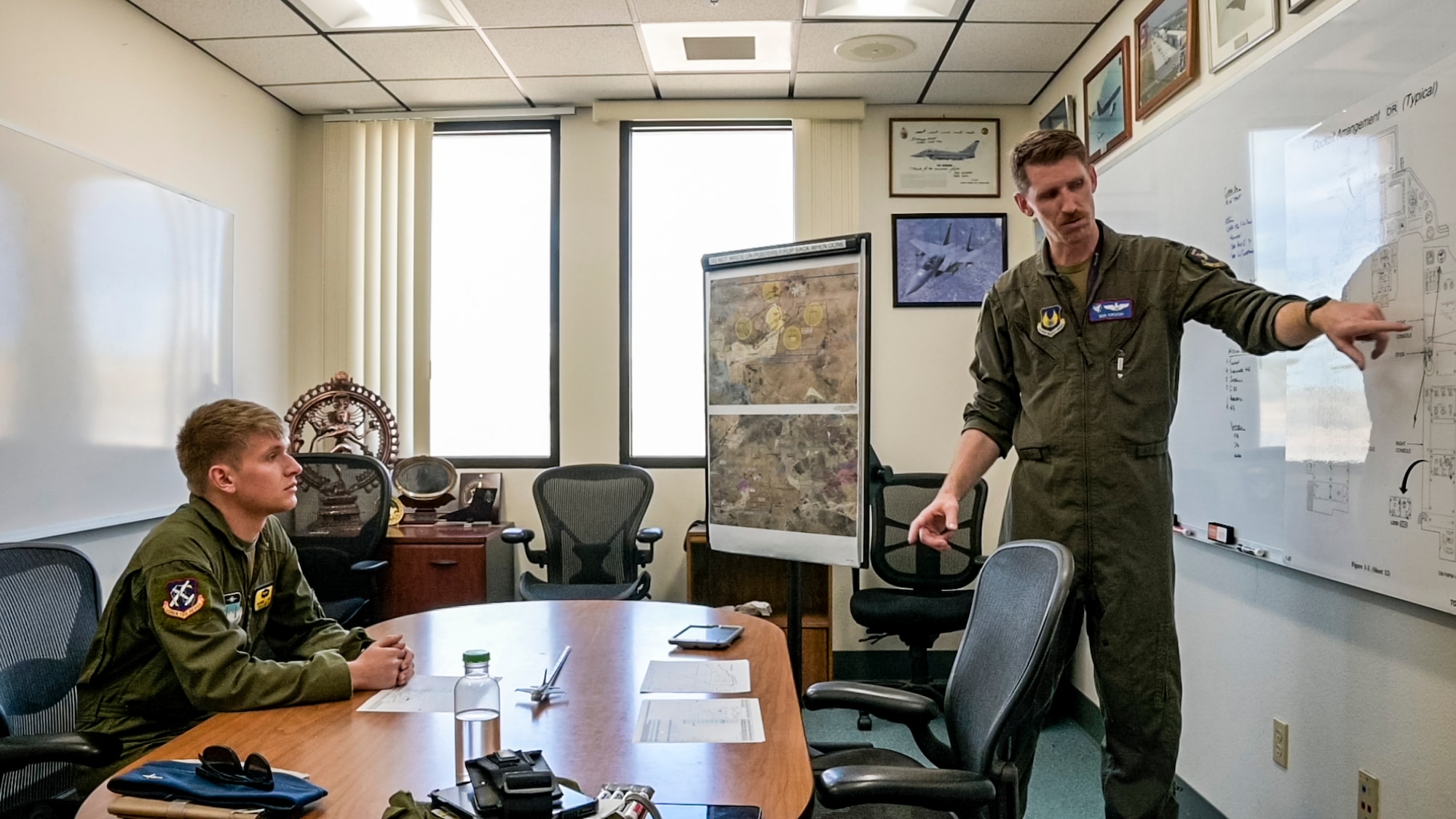 Lt. Col. Kyle Krogh, U.S. Air Force Test Pilot School Director of Operations, briefs U.S. Air Force Academy cadet Nathan Stout on the F-16 Fighting Falcon cockpit, April 12. Stout, along with other Academy cadets, experienced the life of a test pilot at Edwards Air Force Base, California, as part of their Aeronautical Engineering 456 class offered at the Academy. (Air Force photo by Giancarlo Casem)