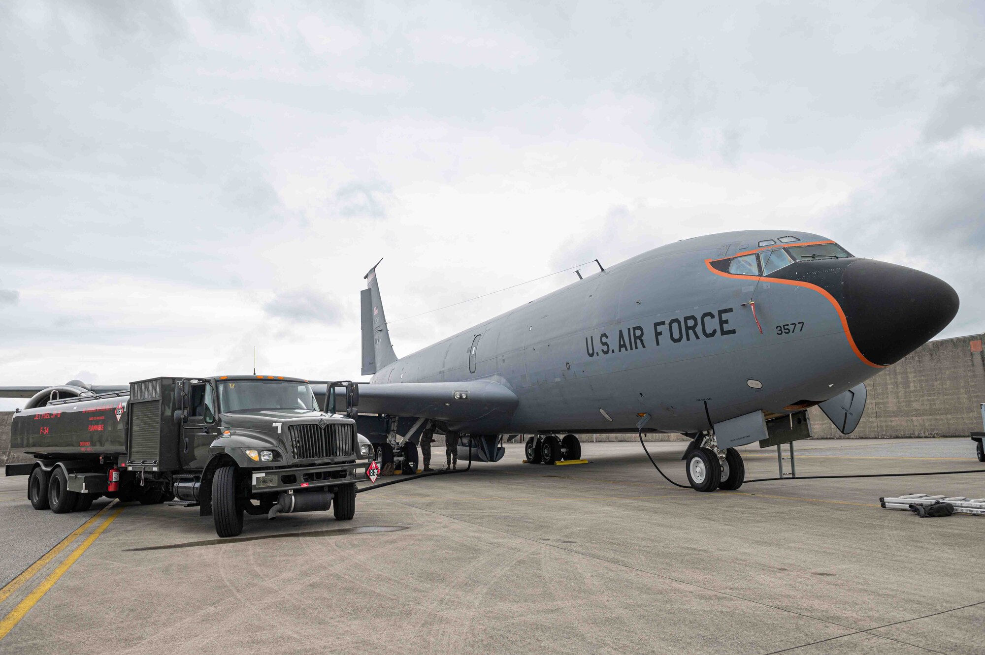 An aircraft and fuel truck sits parked on the flightline