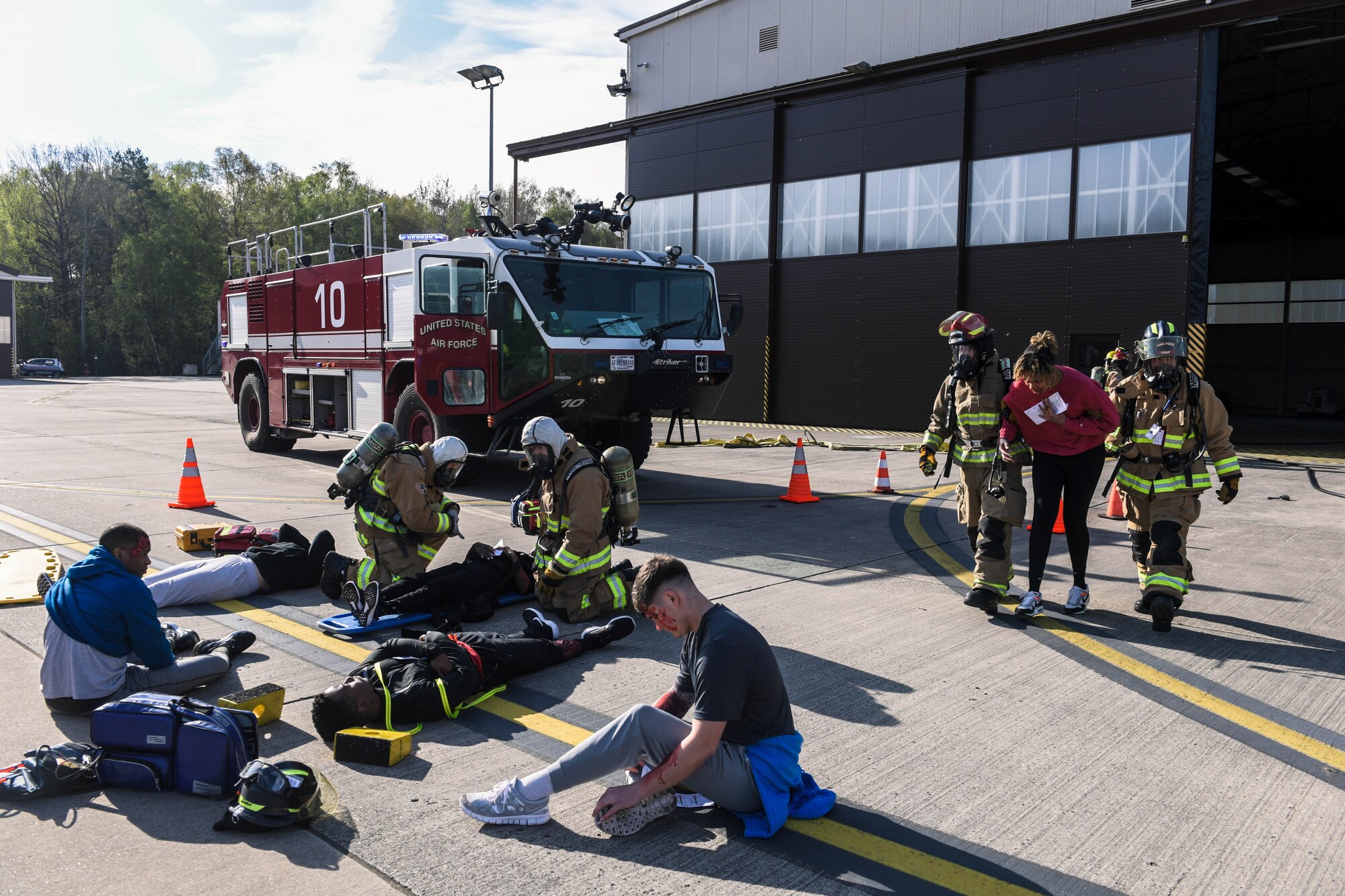 Kaiserslautern Military Community Fire and Emergency Services firefighters provide emergency care to volunteers during exercise Ready Eagle II at Ramstein Air Base, Germany, April 27, 2023. During the exercise, firefighters moved each volunteer from the scene of the explosion to outside of the hangar to provide emergency first aid. Exercises like these provide opportunities for Airmen to train together and improve their readiness.