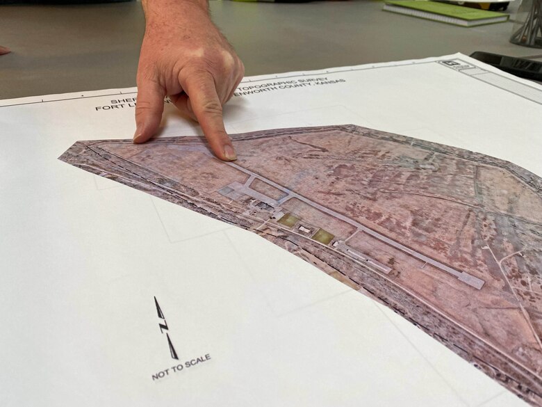 A finger points to a place on a map.