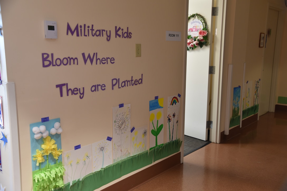 The words: "Military Kids Bloom Where They Are Planted adorn a wall in the child development center.
