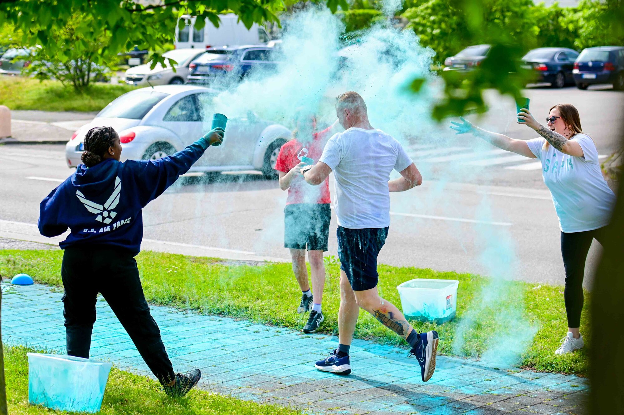 A participant of the Sexual Assault Awareness Prevention Month 5k color run, runs through a color checkpoint