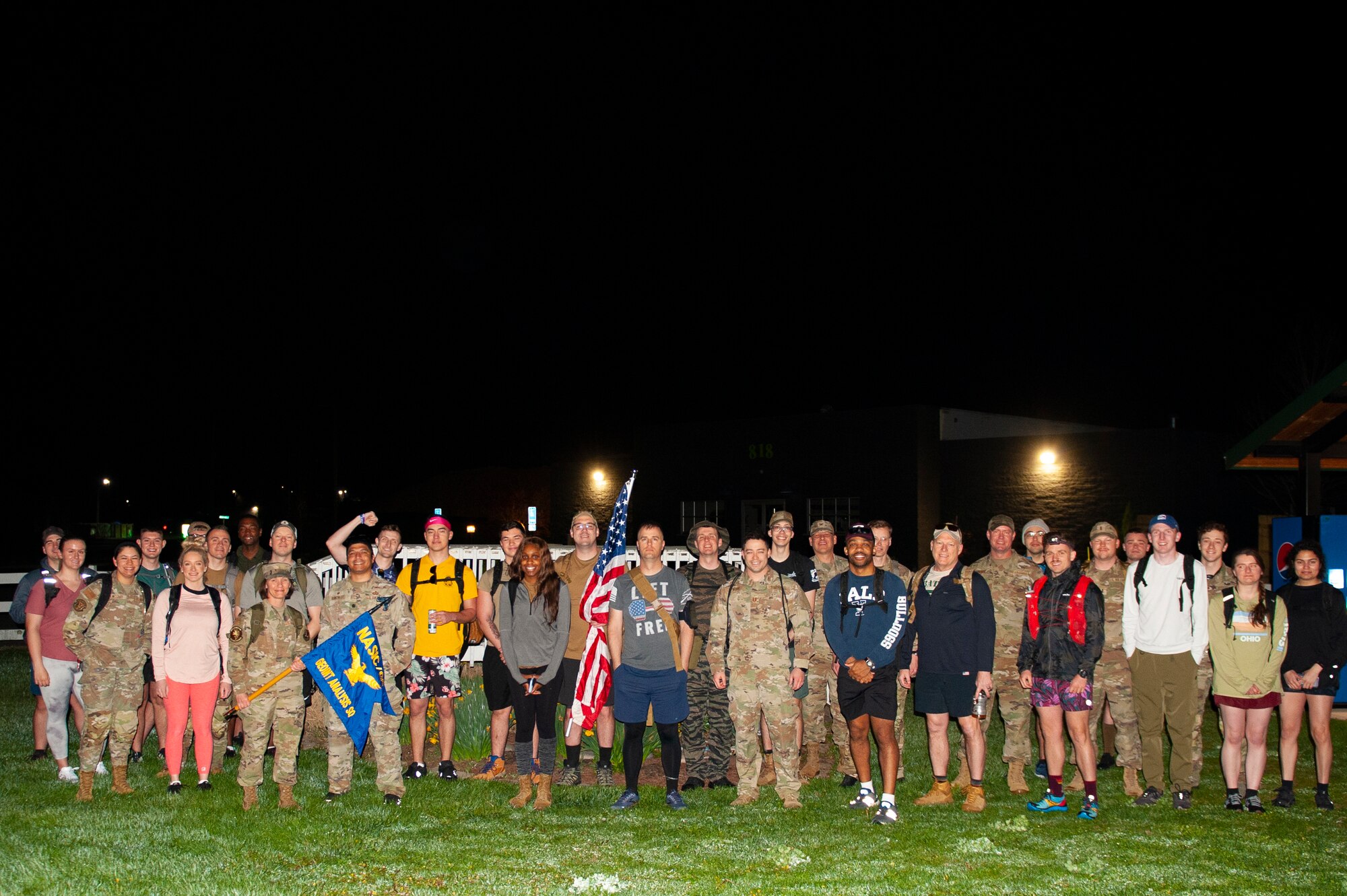 More than 30 civilian and military personnel from the National Air and Space Intelligence Center pose for a group photo before embarking on the Bataan Memorial Death March in Beavercreek, Ohio, April 14, 2023. Organized by U.S. Air Force Technical Sgt. Kyle Townshend and Senior Airman Nathaniel Tillman of NASIC, the ruck commemorates the combined 10,000 American and Filipino soldiers that died in the Bataan Death March, a forced 65-mile march during World War II in April of 1942.