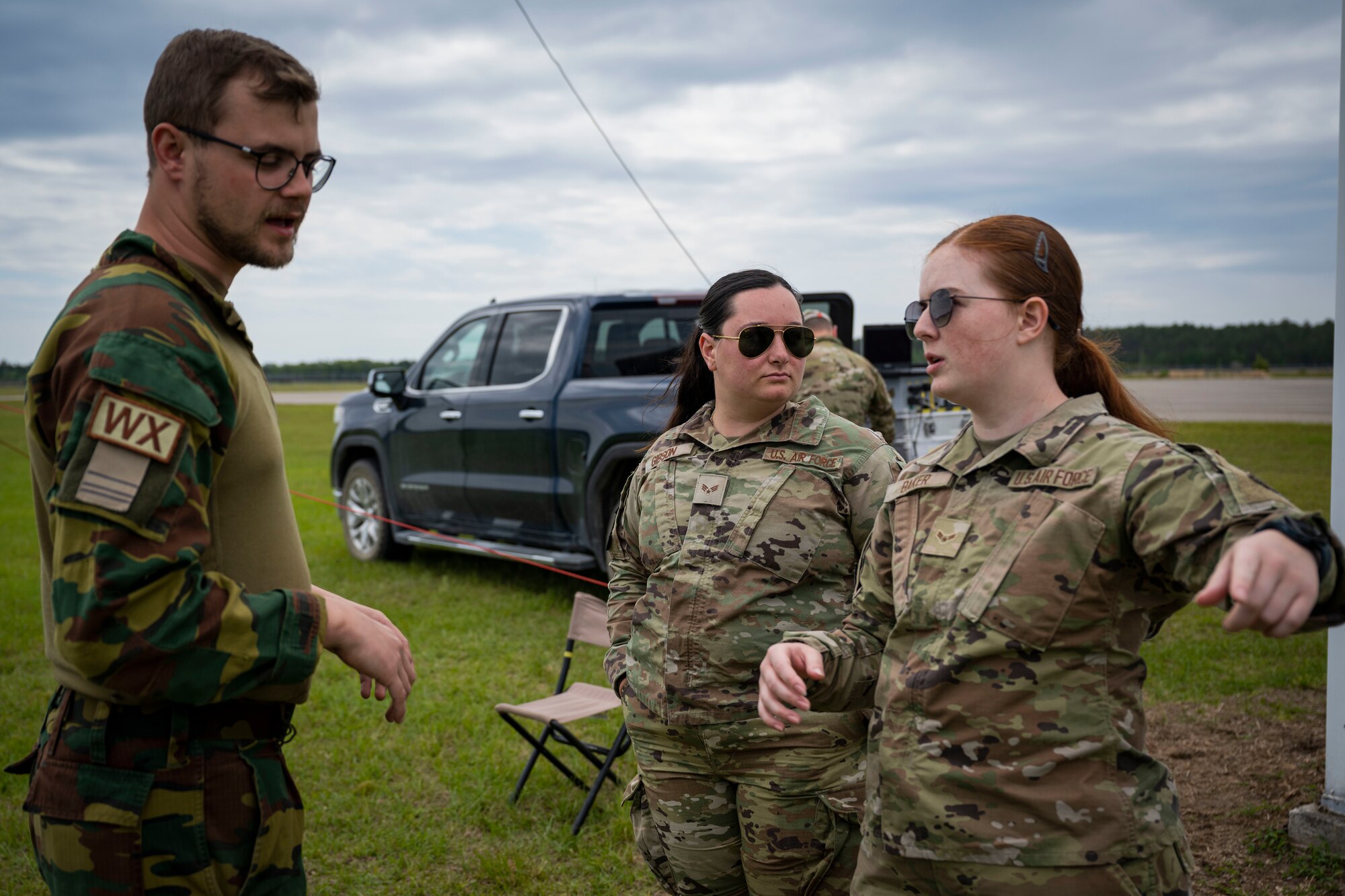 Belgian Air Force Sergeant Jens Boelen, left, Meteo Wing weather forecaster, speaks with U.S. Air Force Senior Airman Samantha Gibson and Airman 1st Class Jayden Baker, 4th Operations Support Squadron weather journeymen, during exercise Southern Strike near Gulfport Mississippi, April 24, 2023. Southern Strike promotes interoperability between special forces, conventional ground forces and air assets to ensure the U.S. military stays relevant and ready to respond to a peer-to-peer large scale combat operation.
