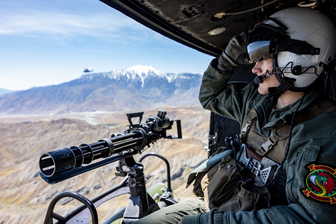 U.S. Marine Corps Cpl. Bryce T. Hubbard, a UH-1Y Venom Crew Chief with Marine Light Attack Helicopter Squadron (HMLA) 367, Marine Aircraft Group 39, 3rd Marine Aircraft Wing, observes surroundings during a training flight during National Training Center Rotation 23-07 in California, April 27, 2023. During the exercise, HMLA-367 supported 75th Ranger Regiment and 3/160th Special Operations Aviation Regiment as the sole rotary-wing fire support element, enhancing joint planning and execution of long-range assault force escort, deep and close air support, and direct-action raids. Hubbard is a native of Sullivan, Illinois.
