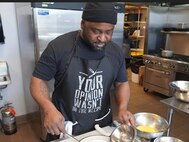 (Photo courtesy Paloma Martinez, Kitchen of Purpose) Sgt. Michael Johnson whips up eggs benedict at the Kitchen of Purpose program.