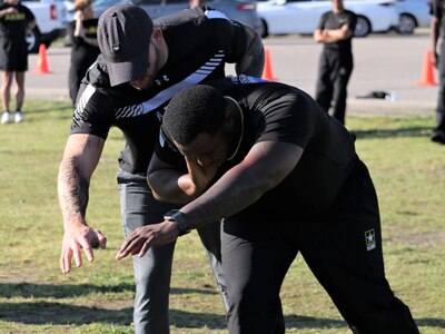 U.S. Army coach Ross Alewine, left, shows Staff Sgt. Bill Anderson some shot put techniques during training at the U.S. Army Adaptive Sports Camp at Fort Bragg, North Carolina, March 30, 2023. Over 70 wounded, ill and injured Soldiers are training in a series of athletic events including archery, cycling, shooting, sitting volleyball, swimming, powerlifting, track, field, rowing, and wheelchair basketball. The Adaptive Sports Camp celebrates wounded, ill, and injured Soldiers' ability to recover and overcome. The Army holds qualifying trials for Active Duty, wounded, ill or injured Soldiers to assess and select athletes for competition in the Warrior Games Challenge. This year, the Warrior Games Challenge takes place in June 2023 at Naval Air Station North Island in San Diego, California. (DoD photo by Robert A. Whetstone)