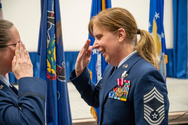 Two women salute in Air Force dress blues.