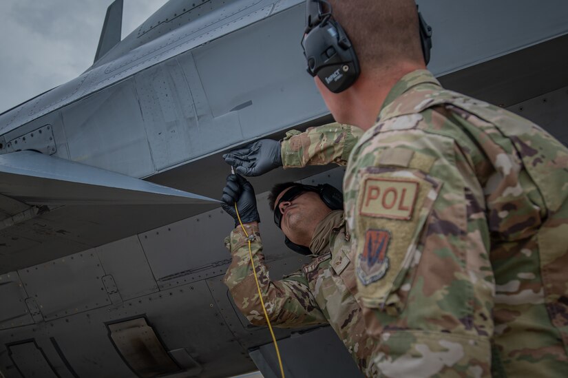 U.S. Air Force Senior Airman Gary Kittrell, 87th Logistics Readiness Squadron fuels service center controller, left, is instructed on how to perform a hot-pit refuel of an F-16C+ Fighting Falcon