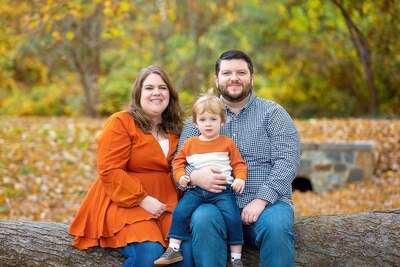 Fall, outdoor family photo of female, male and young child.