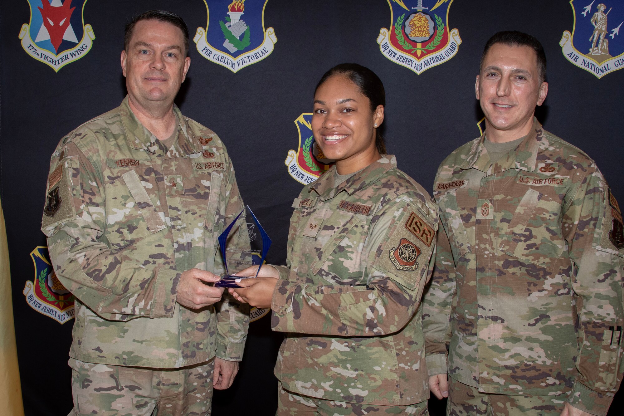 U.S. Air Force Senior Airman Alisha Gosnell, 108th Wing, is presented the New Jersey Air National Guard's Outstanding Airman of the Year award by Brig. Gen. Patrick Kennedy, left, commander of the New Jersey Air Natioinal Guard, and State Command Chief Master Sgt. Michael Rakauckas during the 5th Annual New Jersey Air National Guards Award Ceremony on Joint Base McGuire-Dix-Lakehurst, N.J., May 3, 2023.