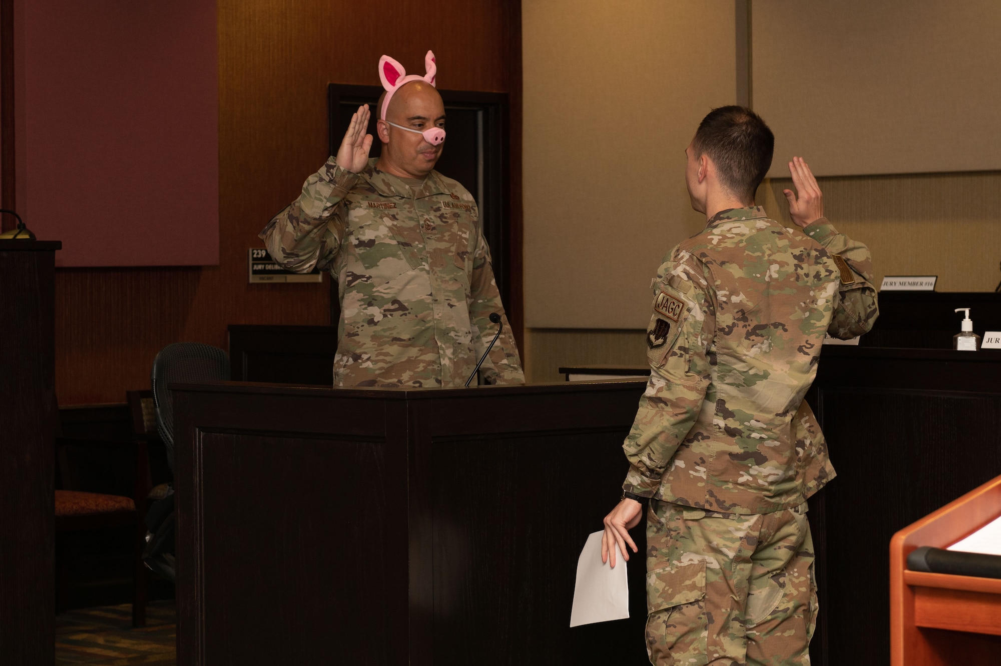 Chief Master Sgt. Peter Martinez, left, 4th Fighter Wing command chief, portrays Pig One, as 1st Lt. Oliver Batkoff, 4th FW JA legal assistant, swears an oath on the stand for direct examination during a “Big Bad Wolf” fairy tale themed mock trial at Seymour Johnson Air Force Base, North Carolina, May 1, 2023. A direct examination is when a witness is questioned to get their version of the story. The event was held as a part of Law Day to help teach students from Carver Heights Elementary School, Goldsboro, North Carolina, about Air Force’s legal profession. Community outreach events help the wing build relations with local communities and is an opportunity for Airmen to mentor future leaders. (U.S. Air Force photo by Airman 1st Class Rebecca Sirimarco-Lang)