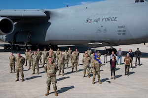 The 724th Air Mobility Squadron poses for a photo in front of a C-5M Super Galaxy aircraft.