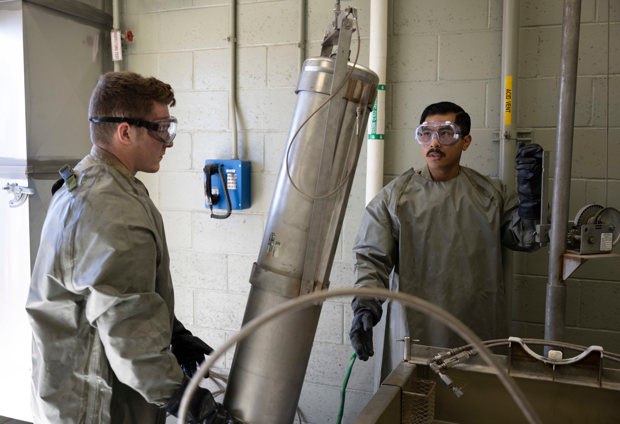 U.S. Air Force Airman 1st Class Cameron Kelley, 49th Component Maintenance Squadron aircraft fuel systems journeyman, left, and U.S. Air Force Staff Sgt. Brandon Millare, 49th CMS aircraft fuel systems craftsman, transport a container of hydrazine at Holloman Air Force Base, New Mexico, April 18, 2023. Hydrazine is a highly toxic and flammable compound that requires strict handling procedures and specialized equipment to prevent accidents and leaks. (U.S. Air Force photo by Airman 1st Class Michelle Ferrari)