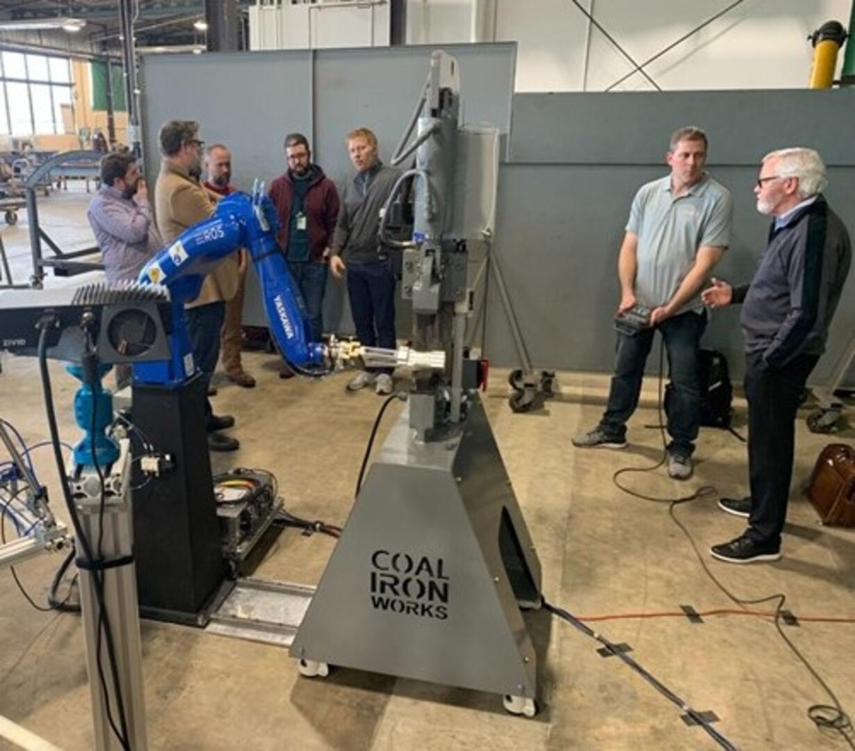 A multidisciplinary development team, comprised of Air Force Research Laboratory, or AFRL, depot, industry and academia representatives, observes the successful first demonstration of an autonomous robotic incremental metal forming prototype, nicknamed AI-FORGE, at Warner-Robins Air Logistics Complex, Georgia, in late January 2023. Personnel from AFRL’s Materials and Manufacturing Directorate, Ohio State University, the Advanced Robotics for Manufacturing Institute, Yaskawa Motoman, and CapSen Robotics collaborated to develop the robotic blacksmithing system, which uses incremental forming, a heat-assisted metalworking process that permits users to manufacture small lots of customized manufactured parts for military aircraft. During its initial test run, the artificially intelligent system operated autonomously without human interruption for over six hours.