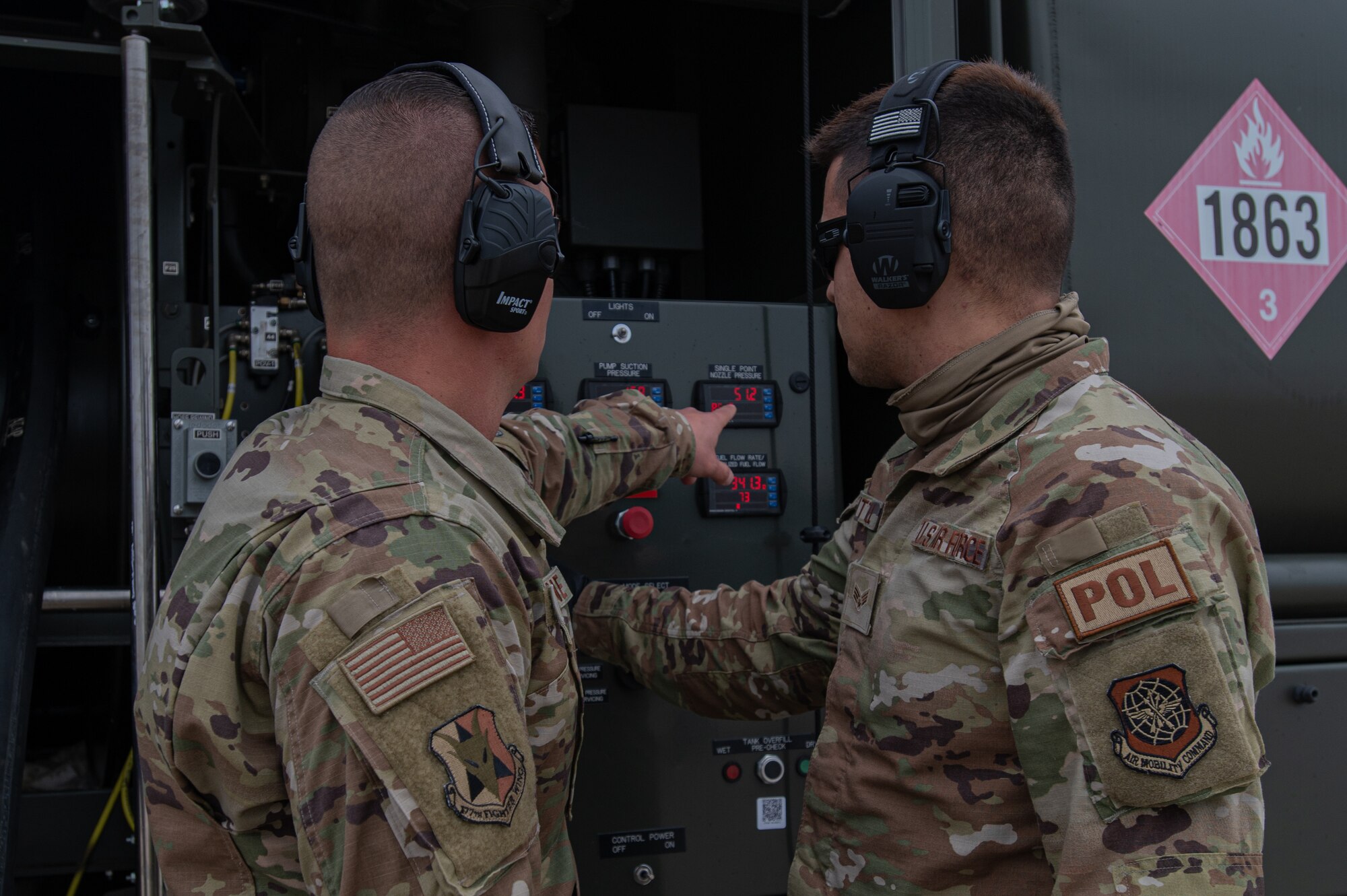 U.S. Air Force Senior Airman Gary Kittrell, 87th Logistics Readiness Squadron fuels service center controller, right, is instructed on how to perform a hot-pit refuel of an F-16C+ Fighting Falcon.