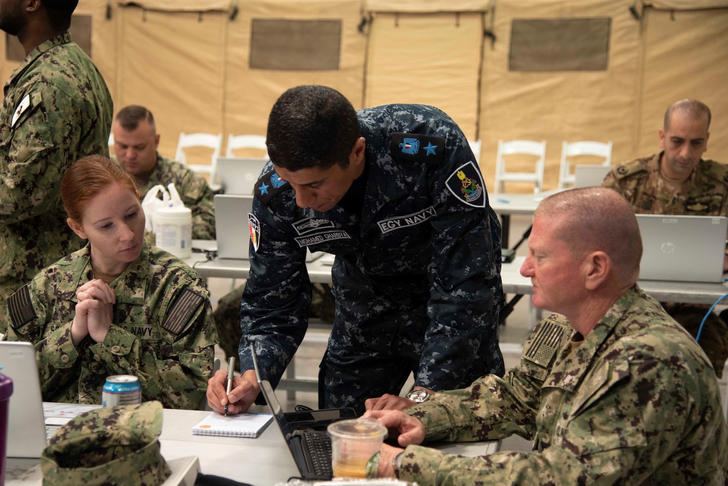 Ensign Kelsey Spangle and Intelligence Specialist Chief Michael Jacobs, both of U.S. Navy Central Command’s Navy Reserve intelligence unit, consult with an Egyptian naval officer during International Maritime Exercise/Cutlass Express 2023, March 12, 2023, in Manama, Bahrain. IMX/CE 2023 is the largest multinational training event in the Middle East, involving 7,000 personnel from more than 50 nations and international organizations committed to preserving the rules-based international order and strengthening regional maritime security cooperation. (U.S. Navy photo by Mass Communication Specialist 1st Class Helen Brown)
