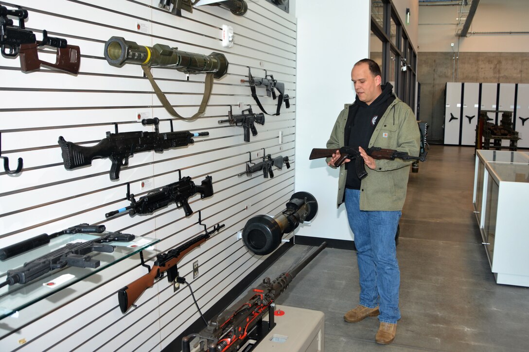 Michael Domalski, a Training Aids, Devices, Simulators and Simulations (TADSS) specialist at Fort Indiantown Gap's Training Support Center, displays a dummy AK-47 that units can use for training on May 1, 2023. (Pennsylvania National Guard photo by Brad Rhen)