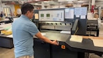 Man uses paper cutter