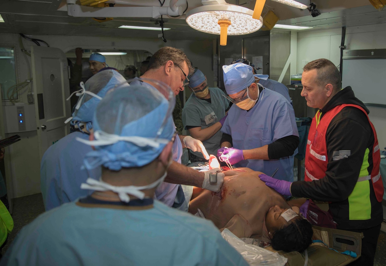 Sailors from Fleet Surgical Team 6 treat a simulated patient aboard the amphibious assault ship USS Bataan (LHD 5) in the operating room during a medical mass casualty drill.