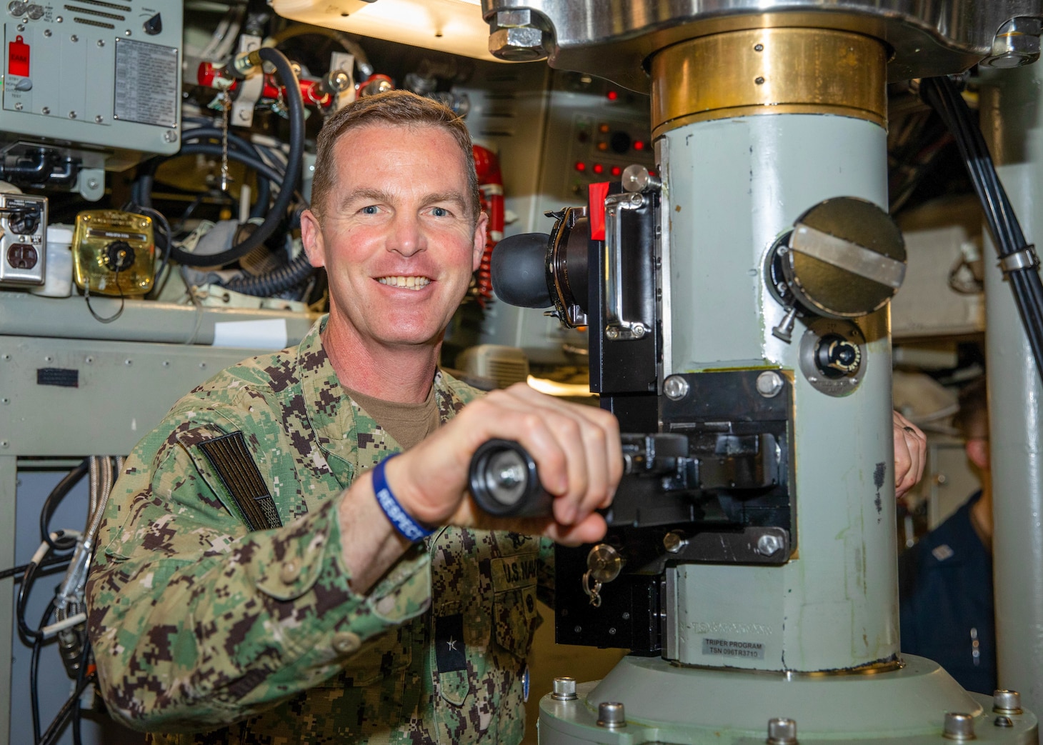 Rear Adm. Mark Schafer, commander, Naval Forces Korea, poses for a photo while using the periscope aboard the Ohio-class ballistic missile submarine USS Maine (SSBN 741), April 18.